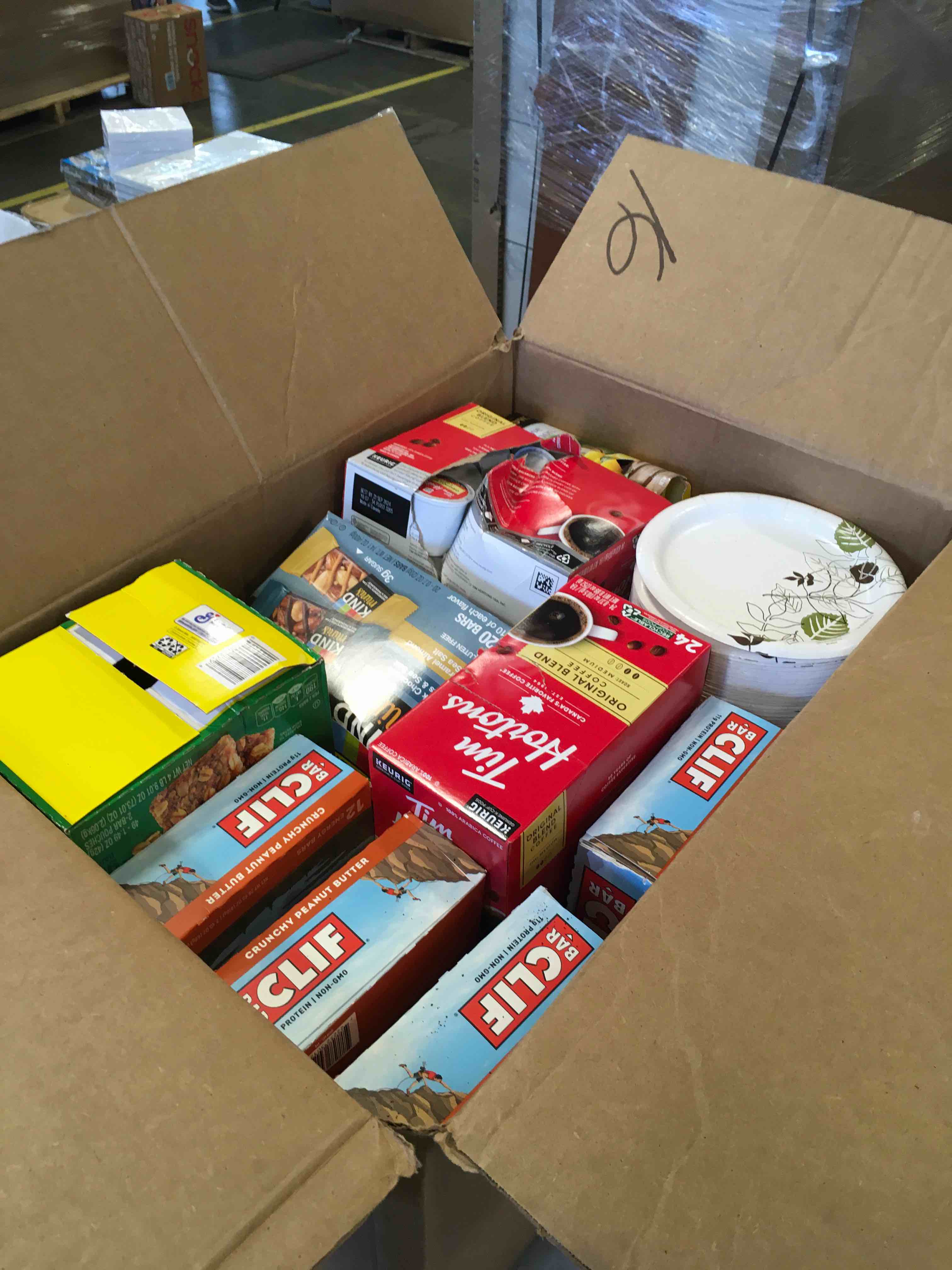 Box of assorted breakfast items including Cliff Bars, Tim Hortons coffee, and Kind bars 