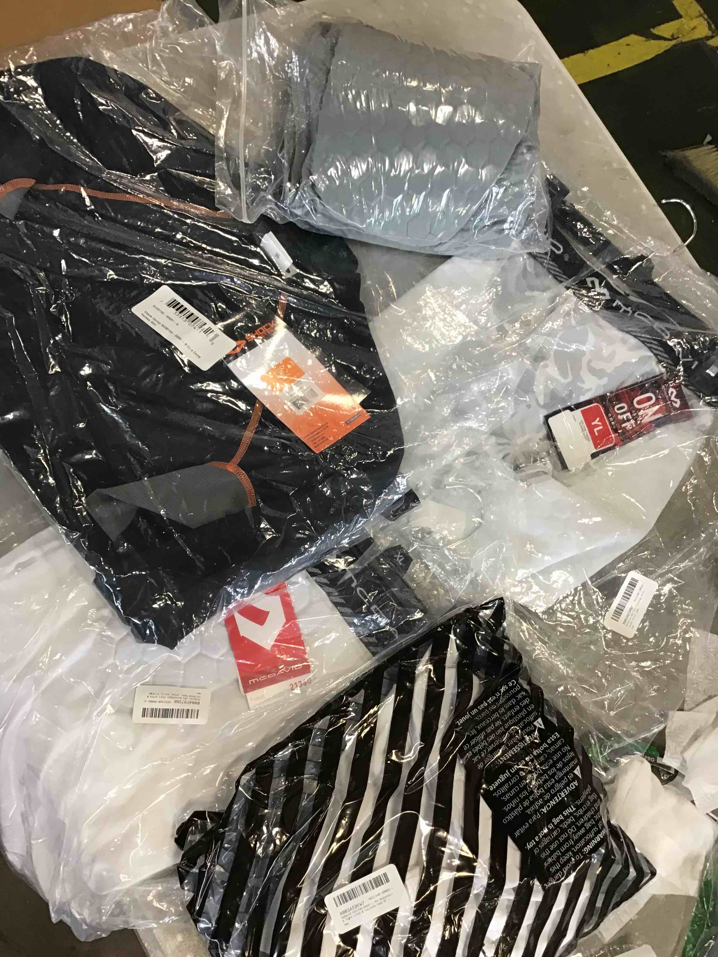 Assortment of Sports Clothes including Tailbone pads, hockey shorts, gloves, Shorts and much more.  very size 