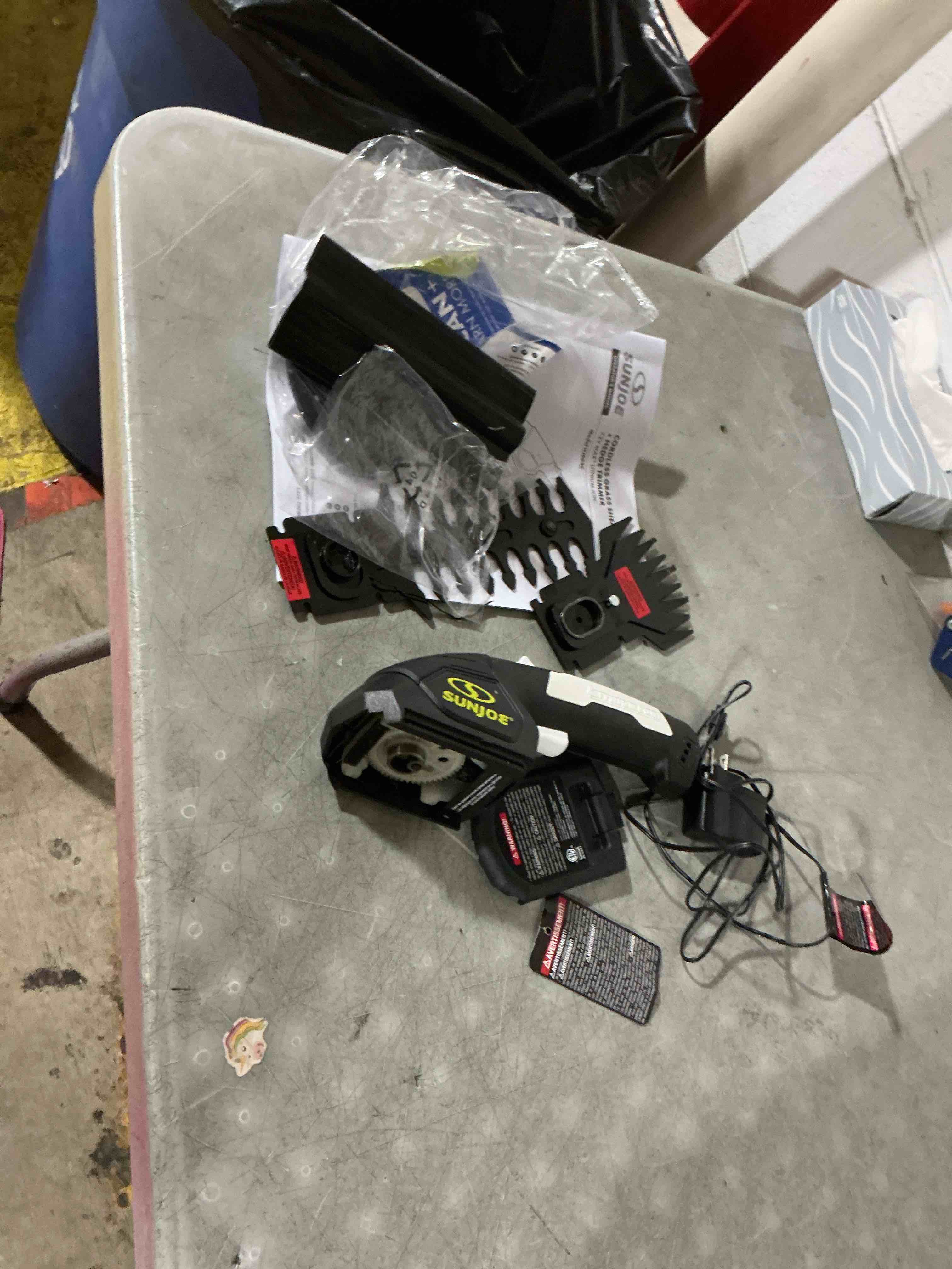 Condition photo showing As Is for sun joe hj604c cordless grass shear + shrubber handheld trimmer, (w/ battery + charger included), green, 7.2v