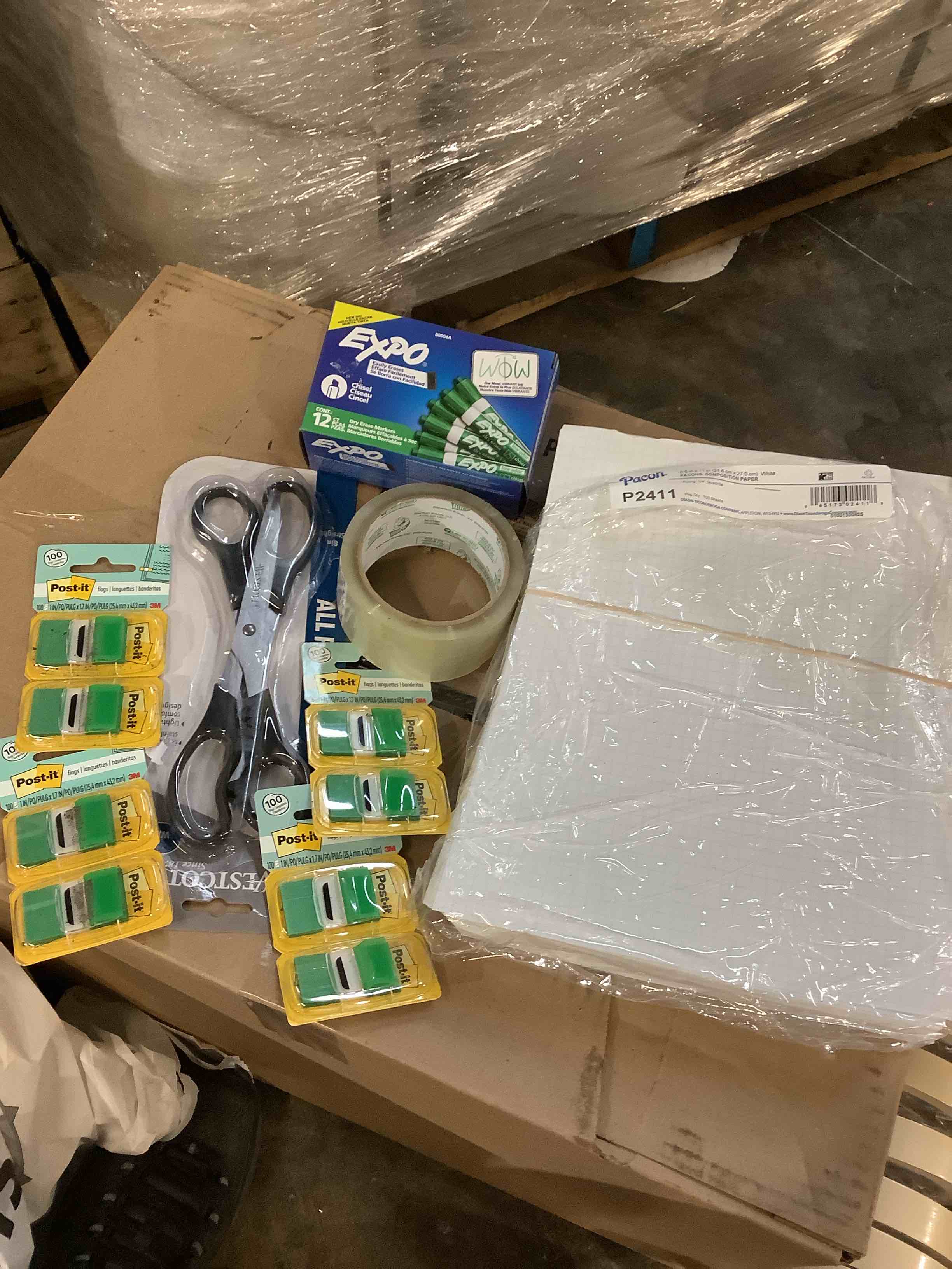 assorted office supplies: Post-it notes, scissors, tape, pack on composition paper, expo, expo, dry, eraser markers, and more