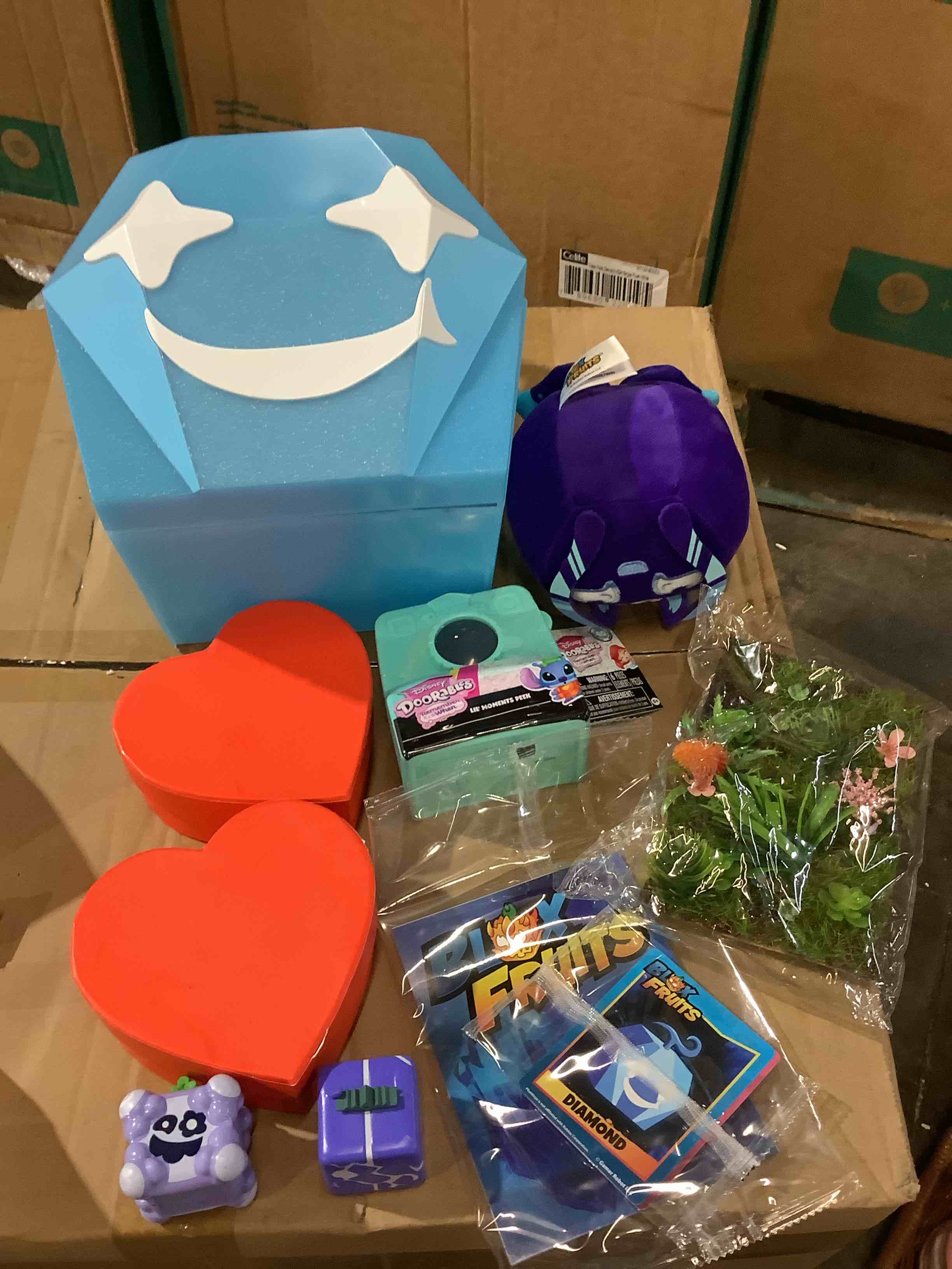 assortment of toys: disney durables, gift boxes, fruits, stuffed animal, decorative greenery, and more
