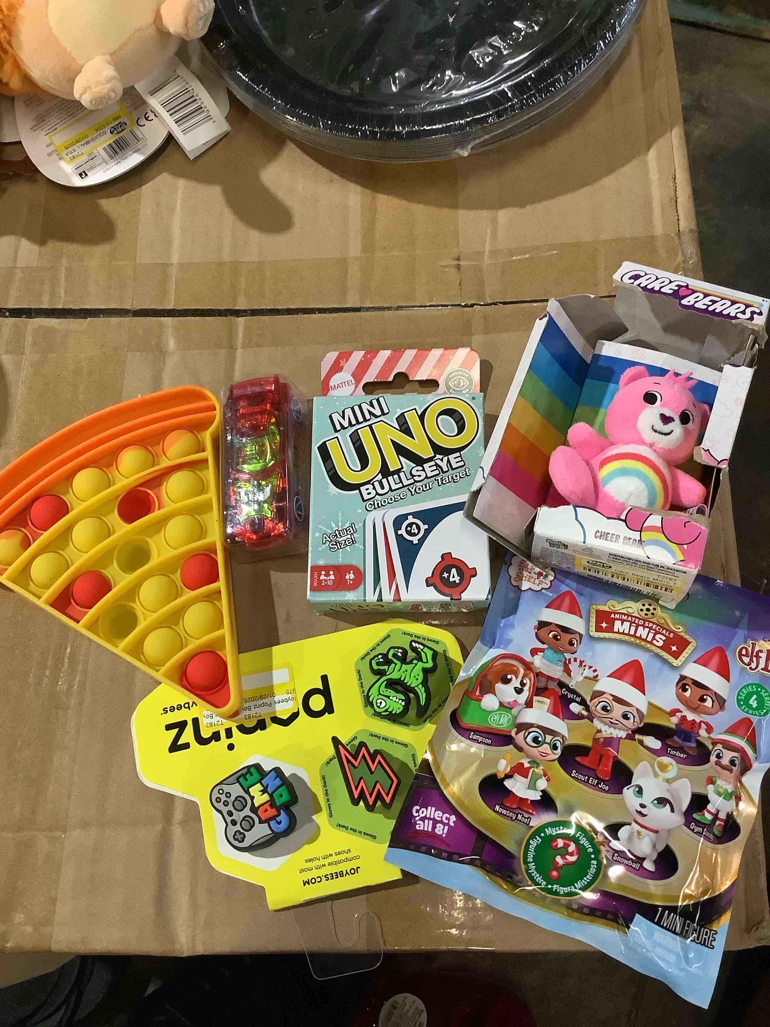 assorted toys: Care Bear, mini elf pets, mini Uno cards, hot wheels, and much