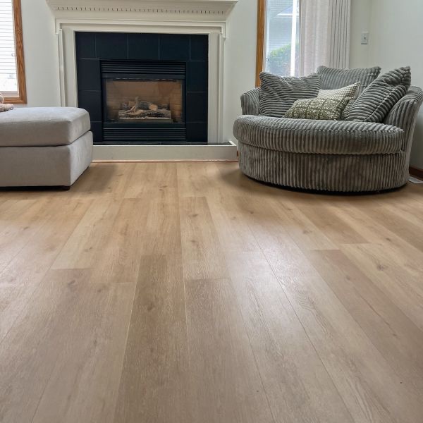 Select Surfaces®’ Riverside rigid core vinyl flooring features a light, natural oak hue with warm beige tones and soft, creamy undertones, enhanced by subtle wood grain detailing.