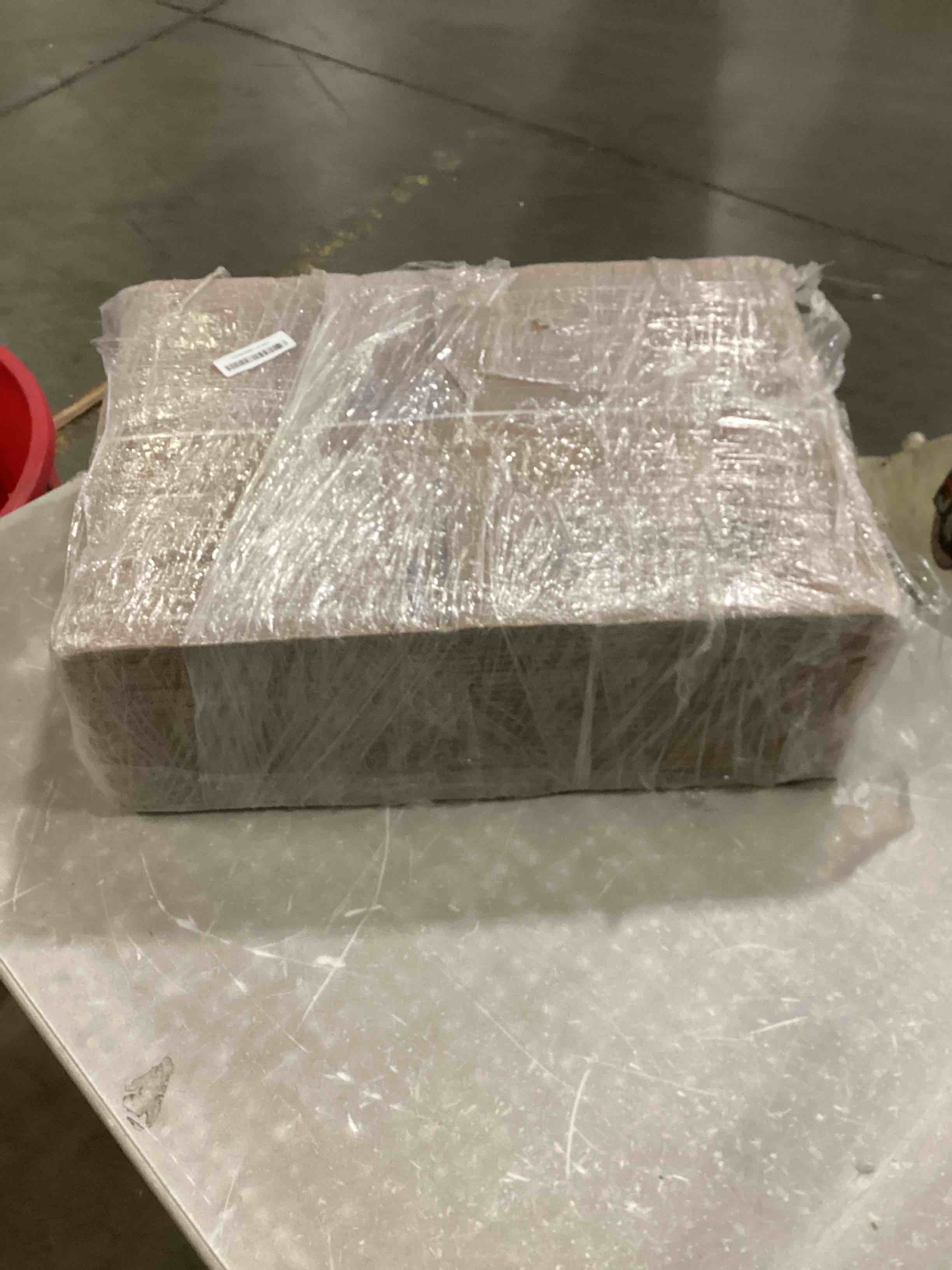 stack of flat, unfolded cardboard boxes secured with a white plastic band