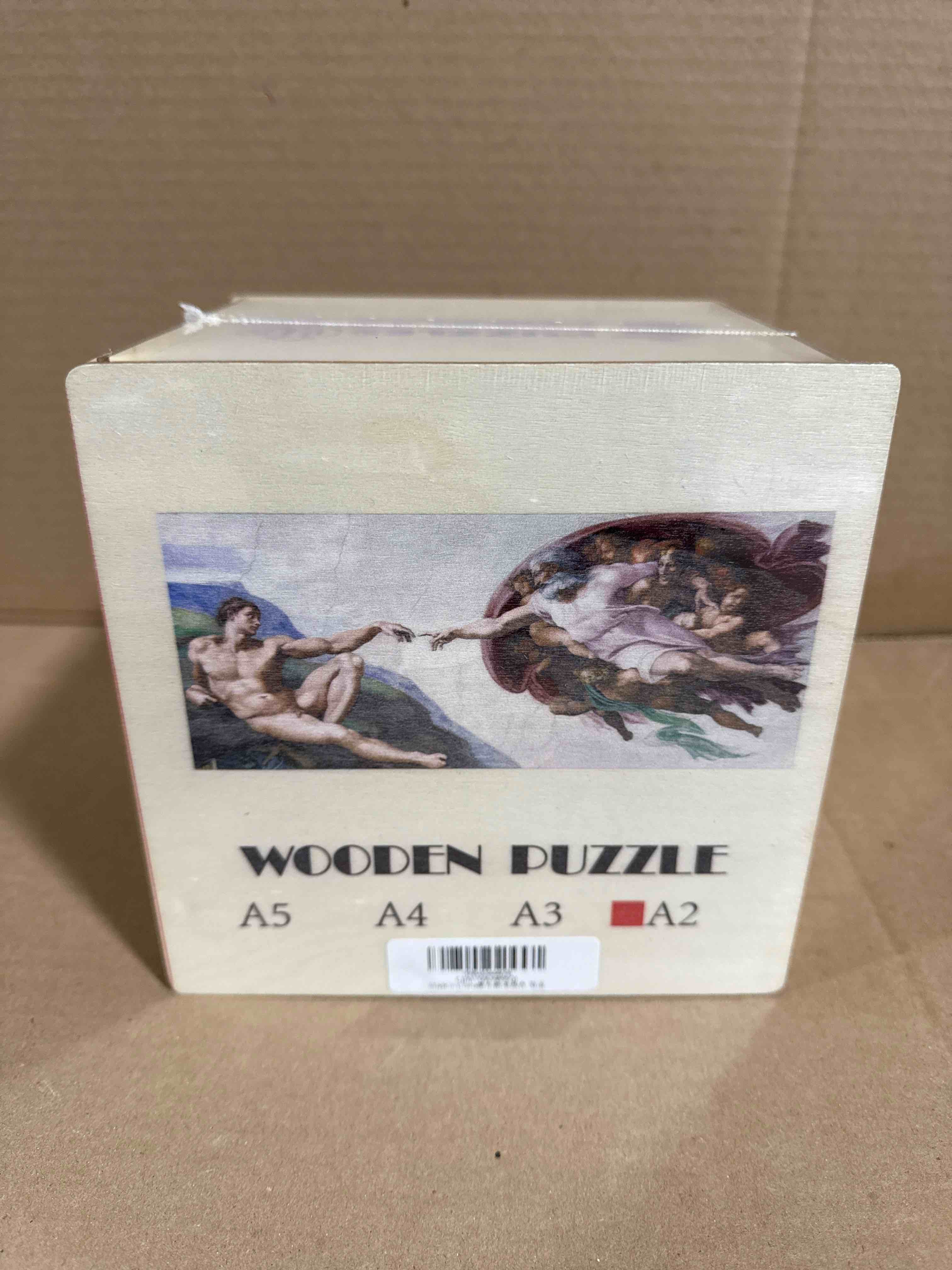 wooden jigsaw puzzle featuring Michelangelo's "The Creation of Adam"