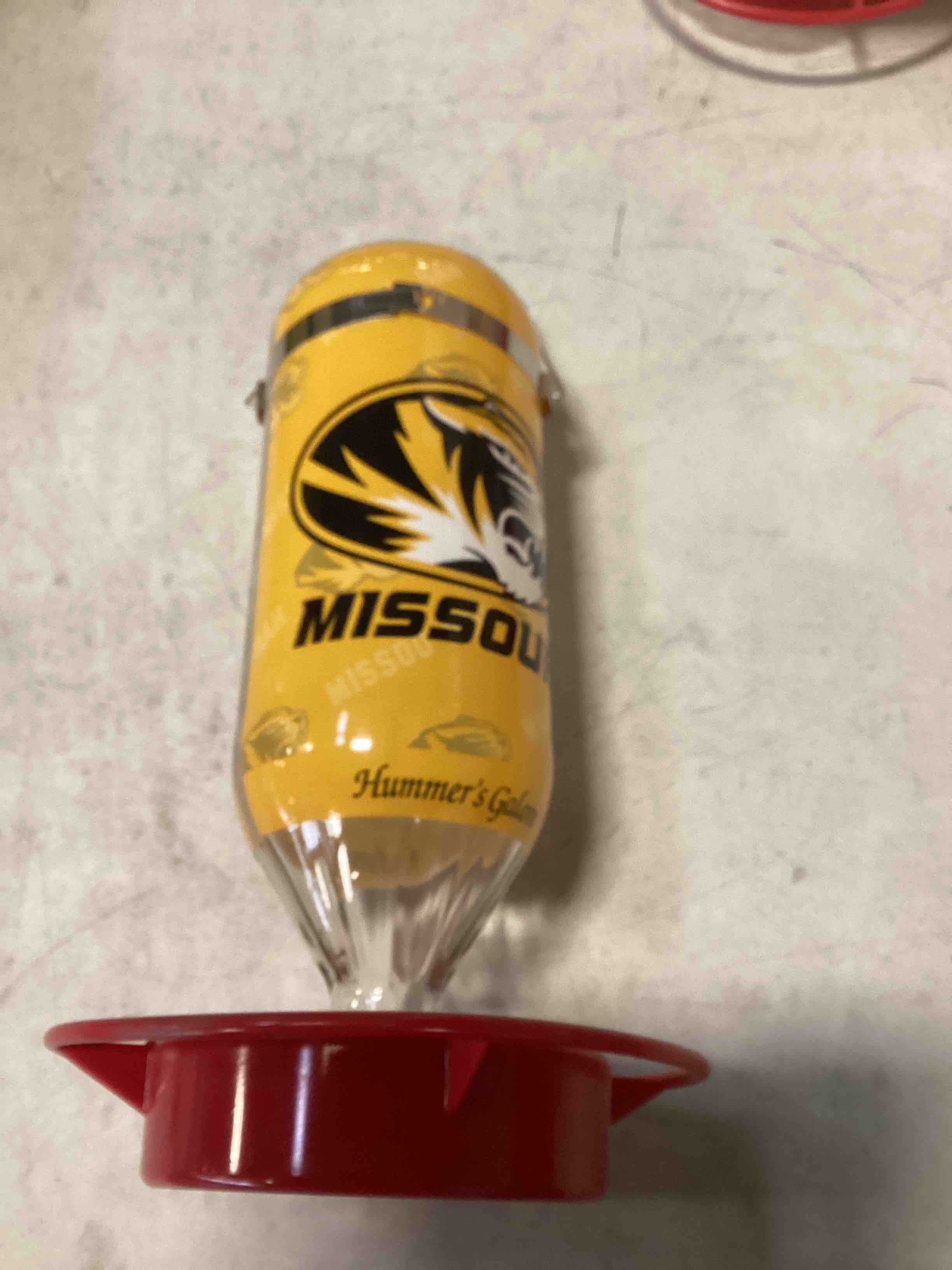 Condition photo showing New/Like New for Hummer's Galore, NCAA College Football Hummingbird Feeder, Glass Hummingbird Feeder with UV Resistant Plastic Wrap for Outdoors Hanging, 32 oz, (Mizzou)