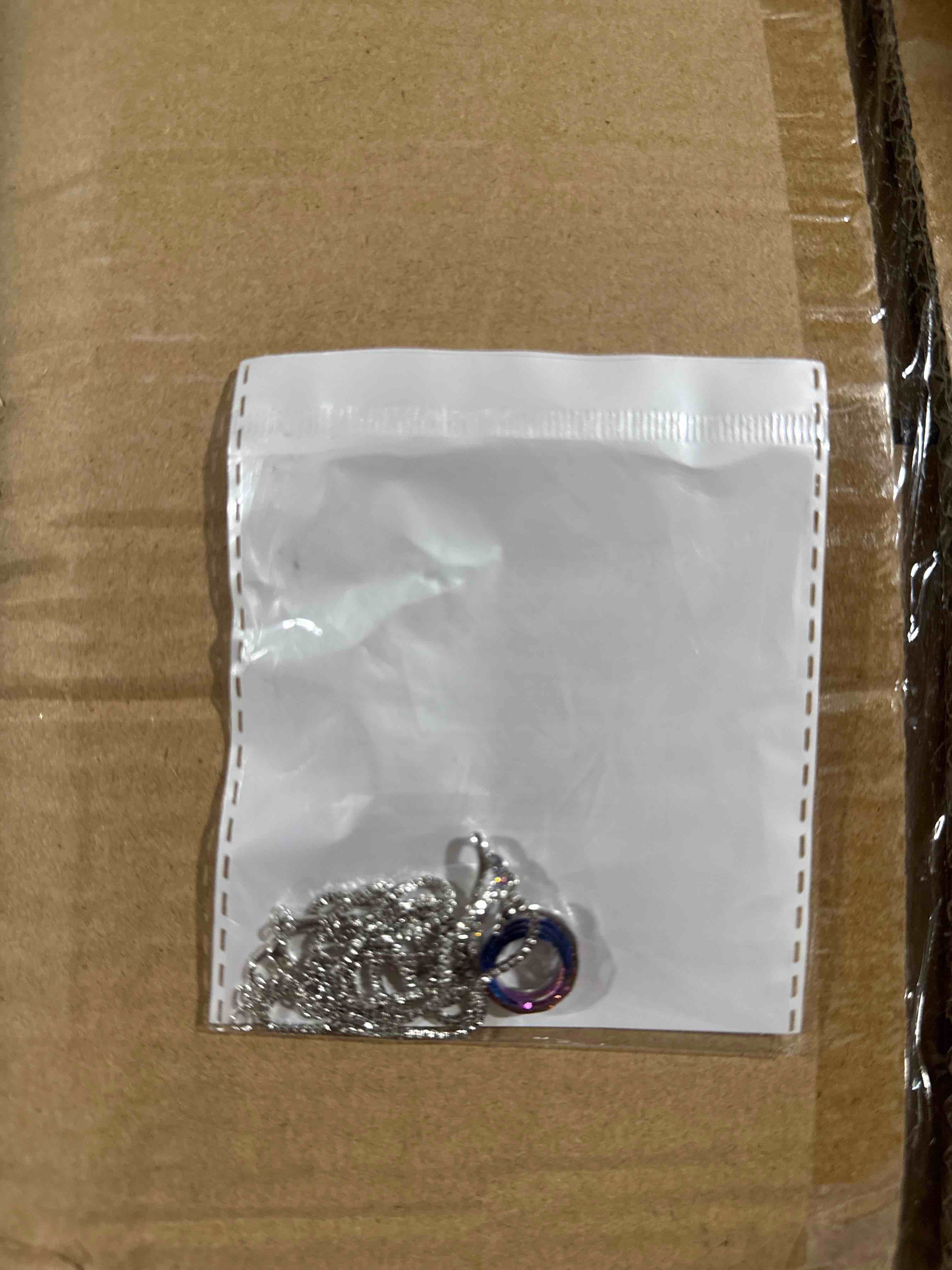 Condition photo showing New/Like New for an elegant silver-tone necklace and bracelet set featuring a radiant purple crystal centerpiece with shimmering accents
