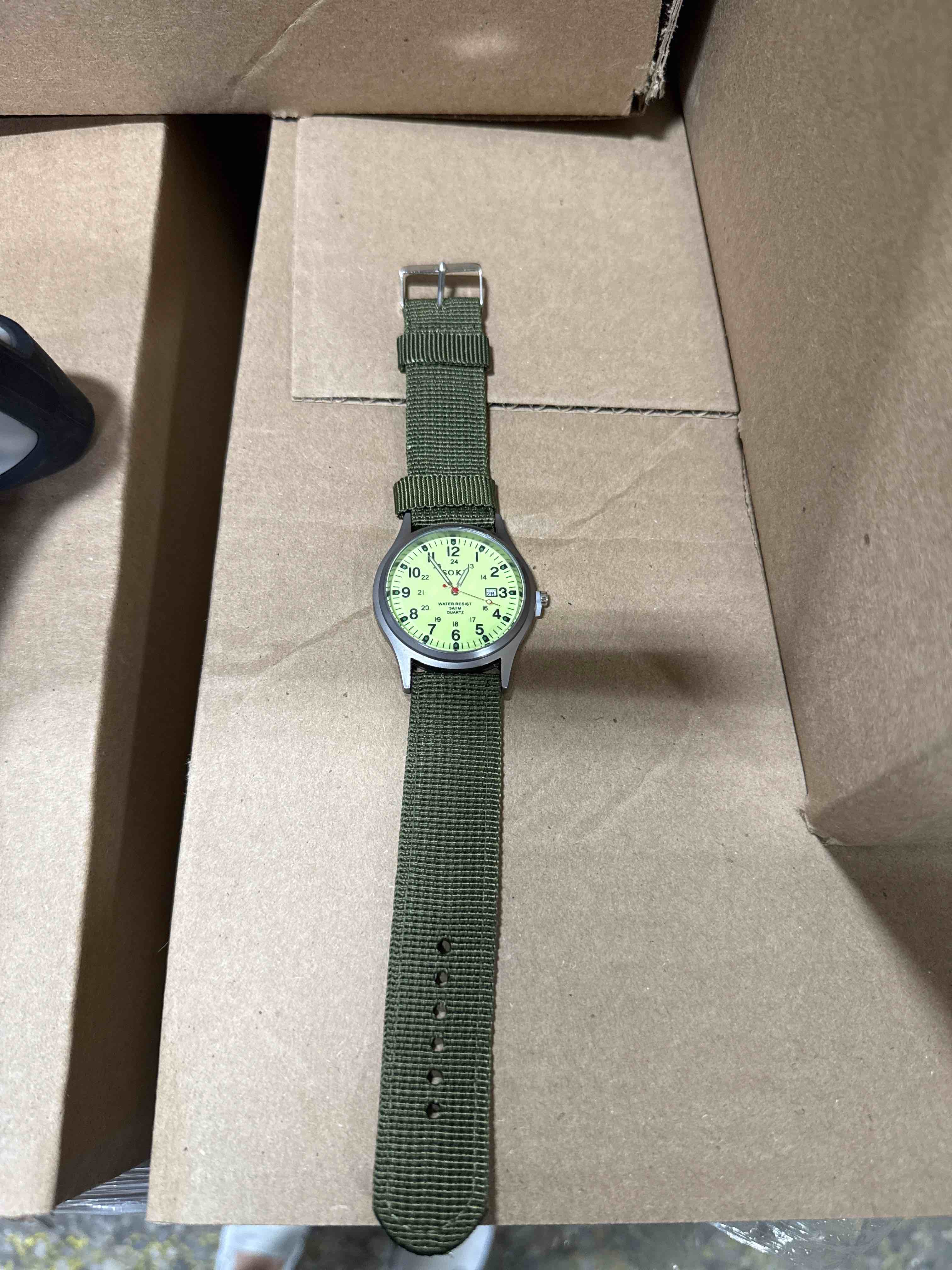 Condition photo showing Brand New for rugged and reliable, this military-inspired field watch features a durable olive-green nylon strap, easy-to-read luminous dial, and convenient date display for everyday wear and outdoor adventures.