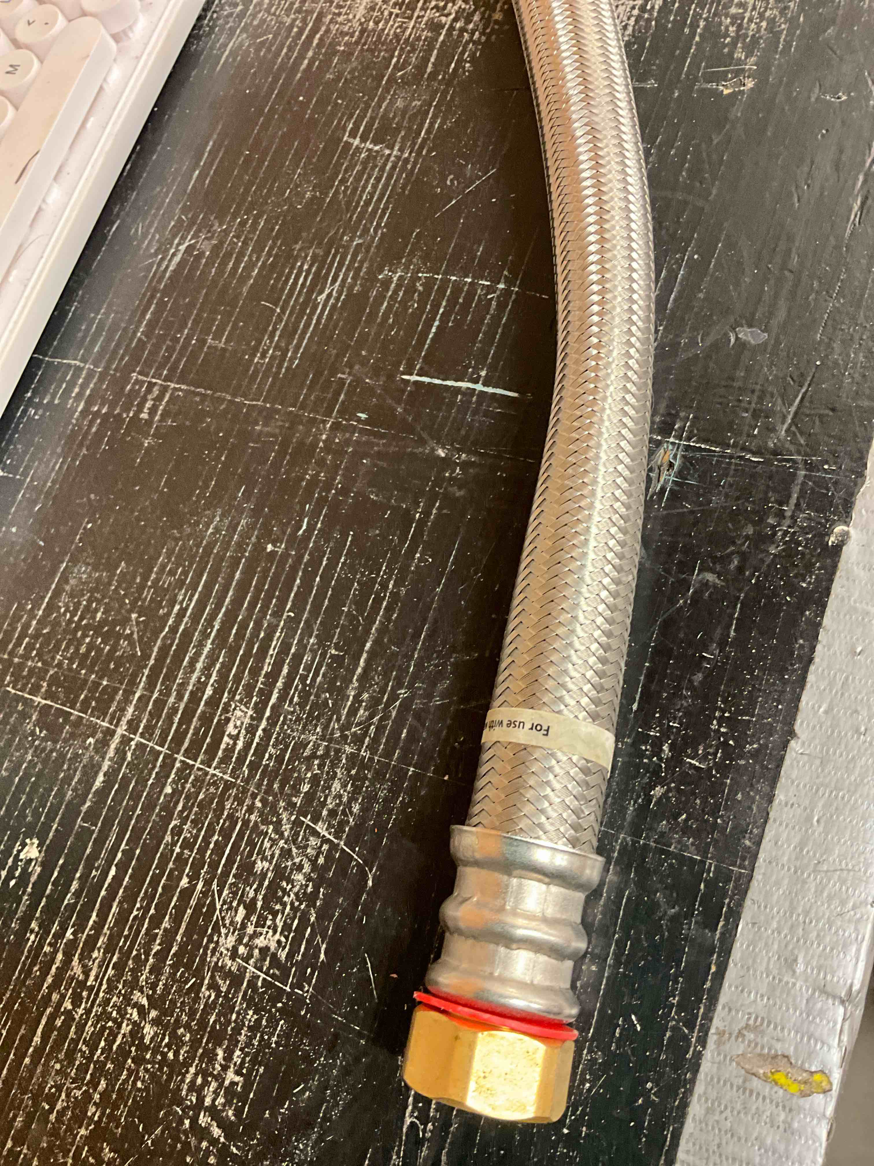 Condition photo showing Good Condition for Signs of use. 3/4 in. FIP x 3/4 in. FIP x 18 in. Stainless Steel Water Heater Supply Line