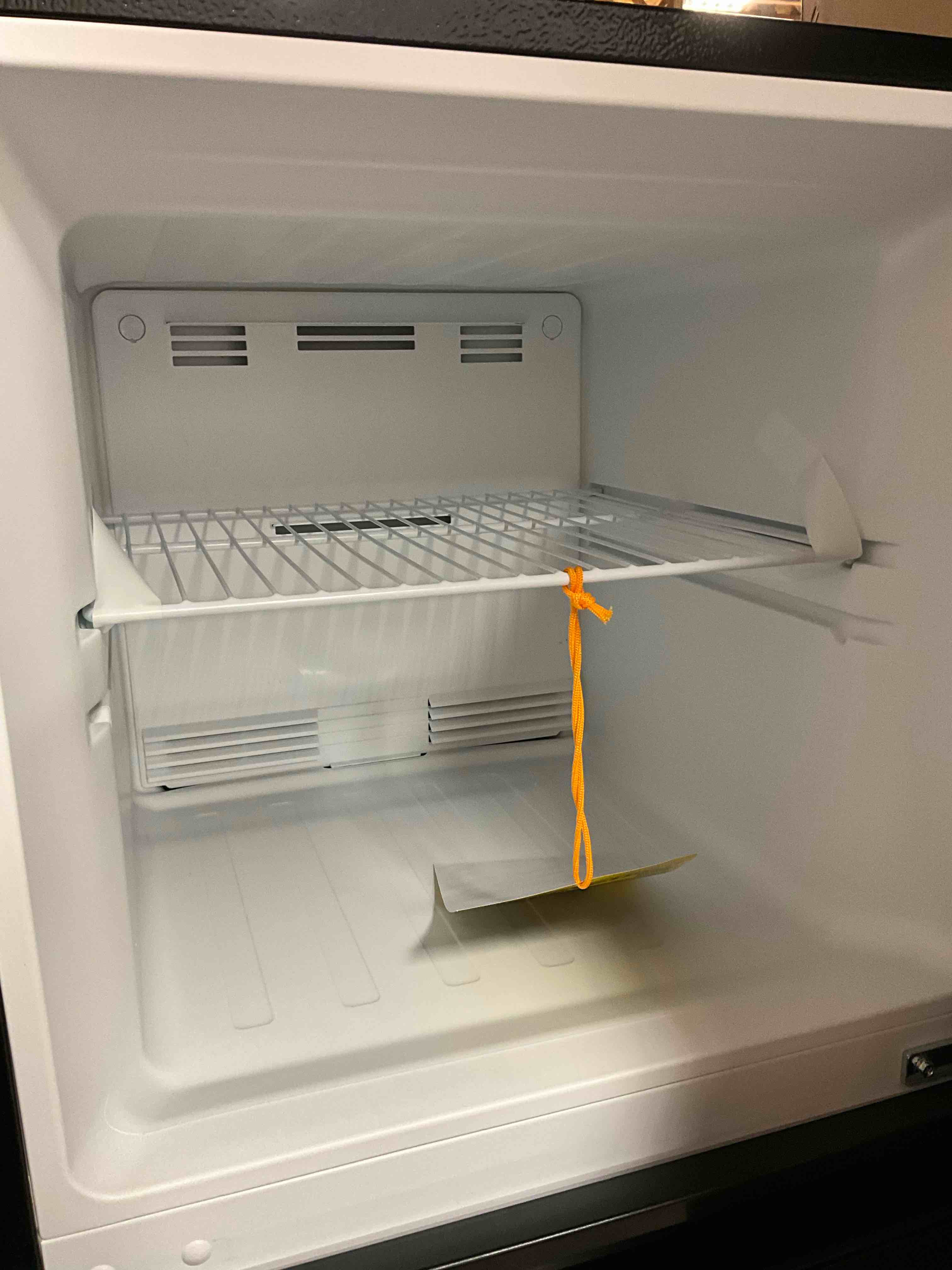 Condition photo showing Good Condition for Dented on top corner. Working Condition Verified. 10.1 cu. ft. Top Freezer Refrigerator in Black, Garage Ready