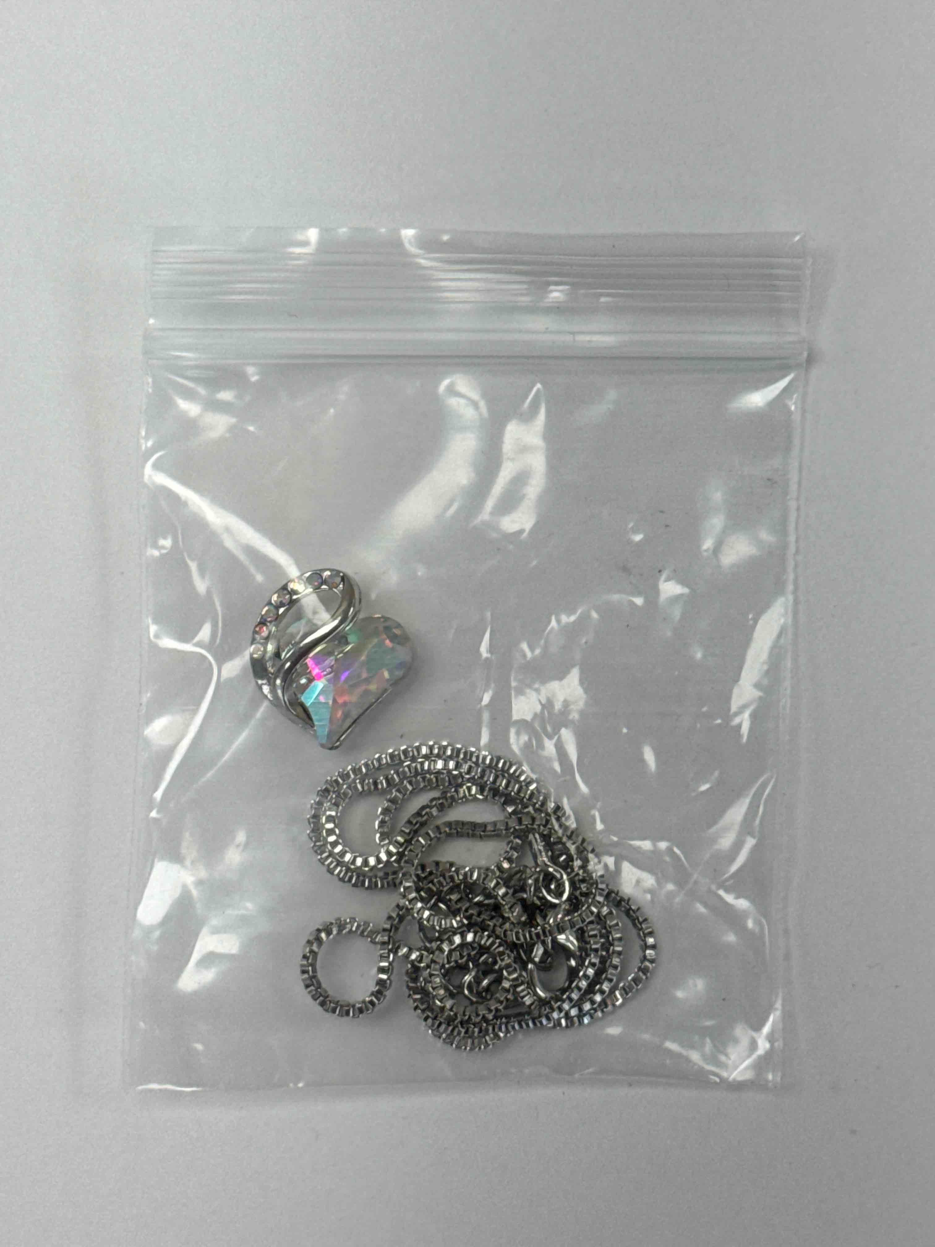 Condition photo showing New/Like New for elegant heart pendant necklace with sparkling crystals and silver chain