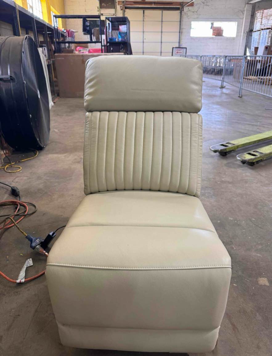 Condition photo showing Good Condition for armless power recliner in almond vegan leather with 3 settings. features line tufted cushions and tan sides (see lot photos for exact item) 