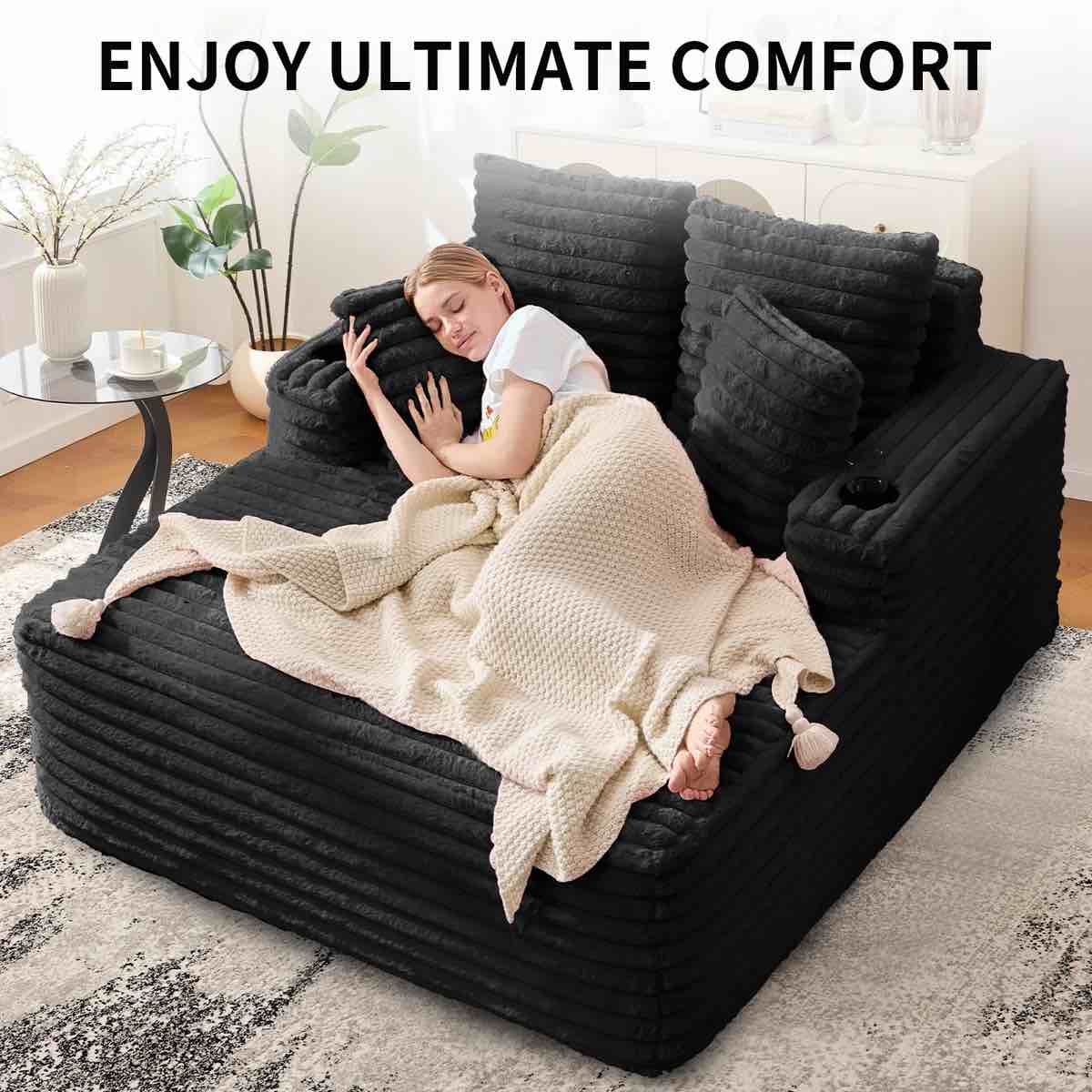 Condition photo showing New/Like New for Oversized 53 Inch Black Plush Sofa Bed with Throw Pillows, Cushioned Armrests, & 2 Cup Holders. Metal inserts for holders can be purchased separately.