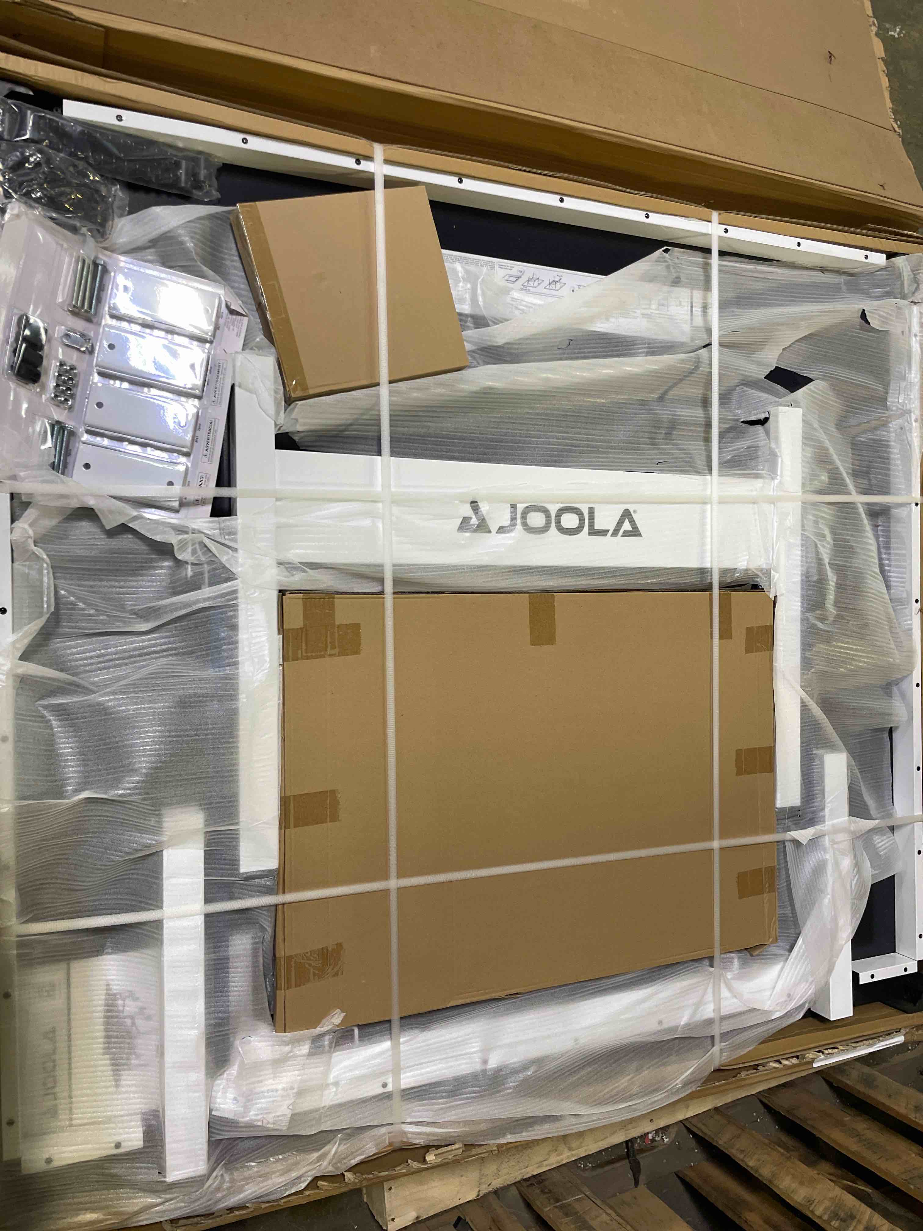 Condition photo showing New/Like New for Joola Rapid Play 250 Indoor Table Tennis Table with Net Set 25Mm Thick. Solo playback mode compatible, High-quality net and post set included, Mounted on a 50 x 50mm white undercarriage. Automatic folding legs with leg levelers, Trolley system of 4 locking casters under each half, Dual safety locking devices to ensure safety when the table is in both playing and storage positions. Dimensions: 9ft x 5ft x 2.5ft