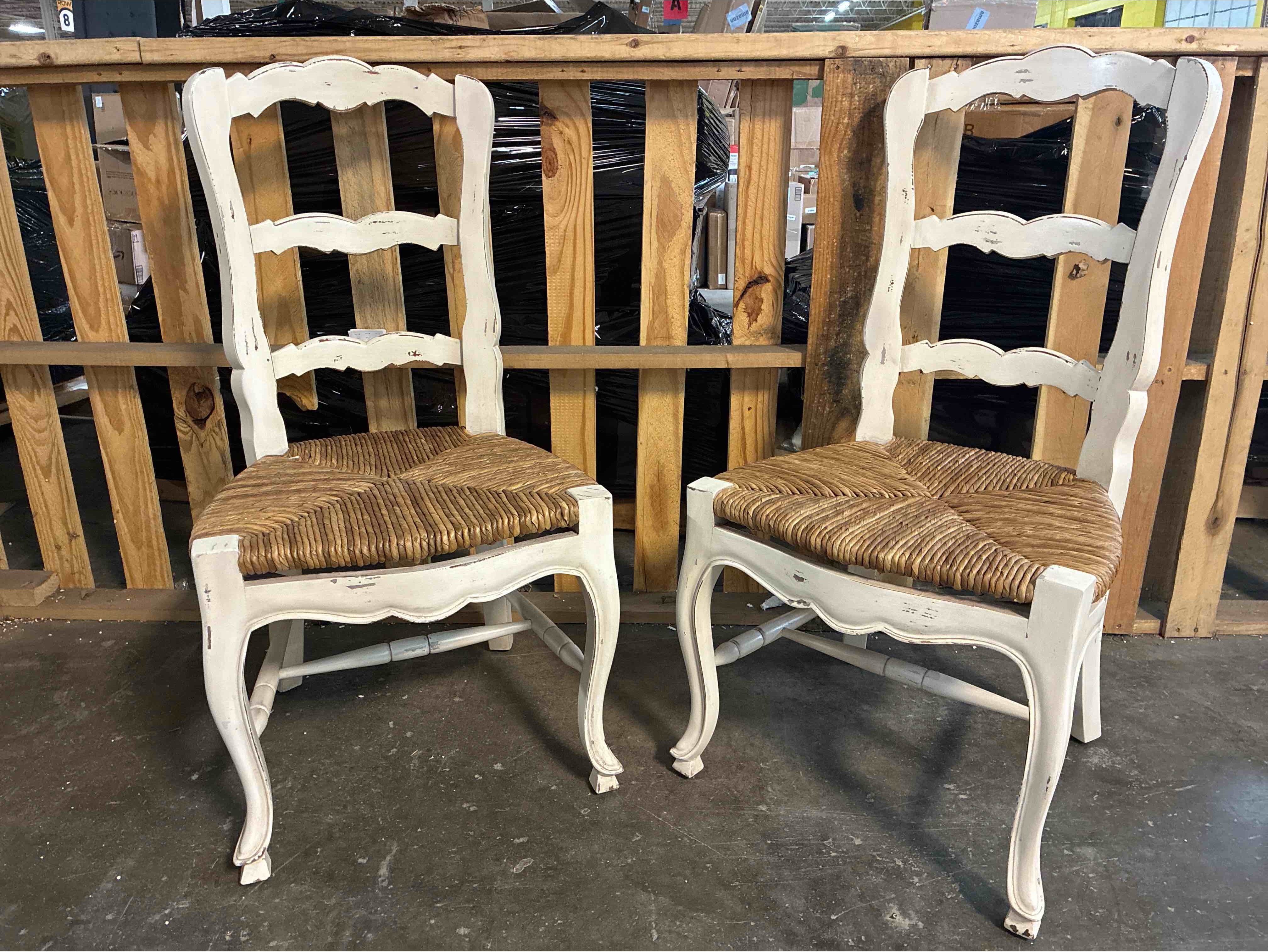 Condition photo showing New/Like New for French Ladderback Distressed Chalk White Mahogany Dining Chairs with Hand Tied Rush Cushioning, Set of 2. 22"W x 20"D x 41"H