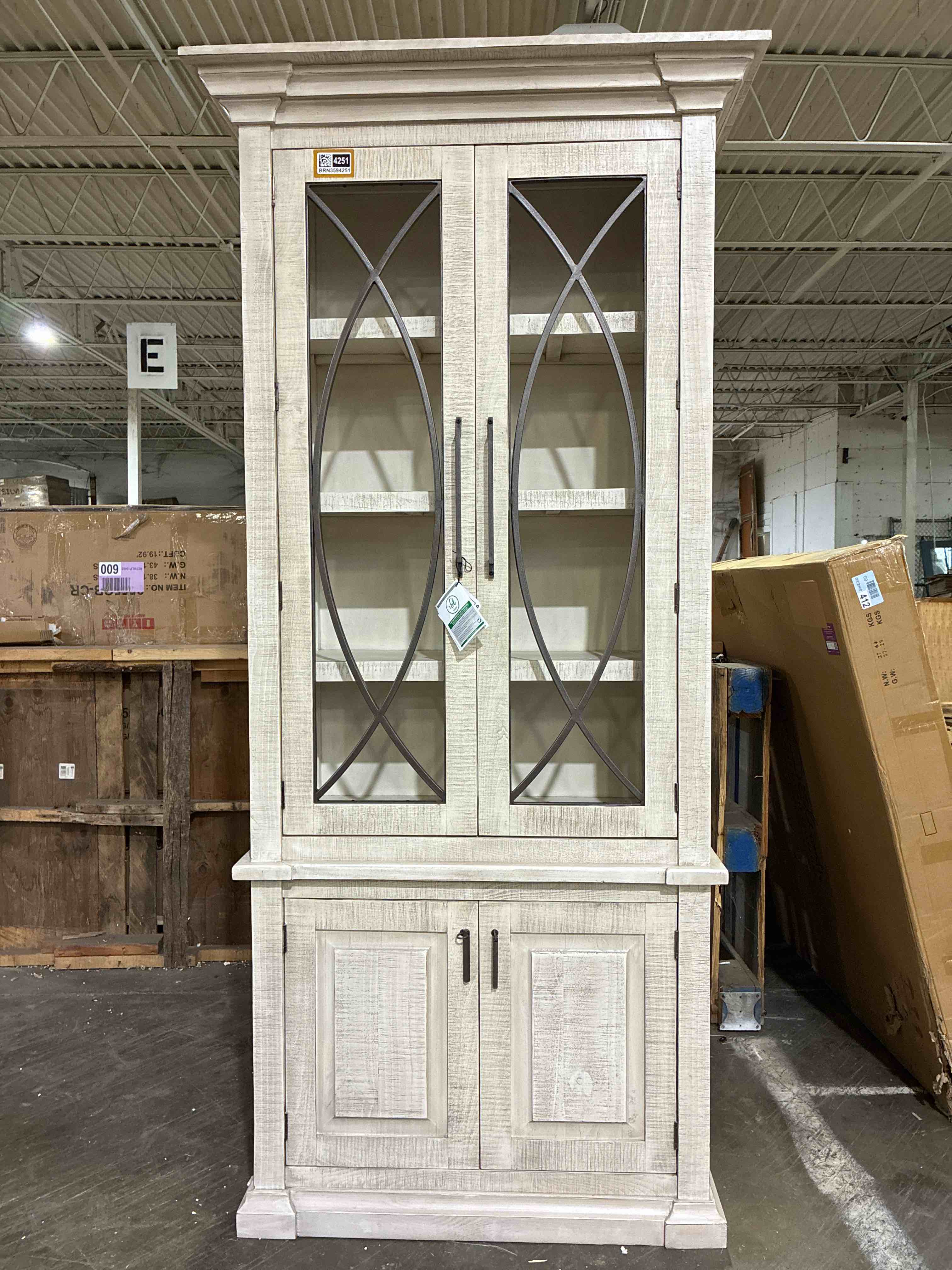Condition photo showing New/Like New for giovo weathered white wooden 2 door 3 shelf dining china cabinet with 2 door base cabinet and iron handles by wildon home. cosmetic chip along top right corner, is considered brand new.