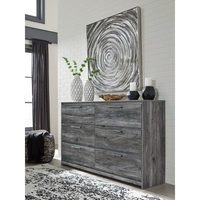 Signature Design by Ashley Baystorm Rustic Smoky Gray Coastal 6 Drawer Dresser with Rubbed Iron Handles. Some damage to right base side, does not effect function of drawer. Front in beautiful condition. 58.98"W x 15.59"D x 36.77"H 