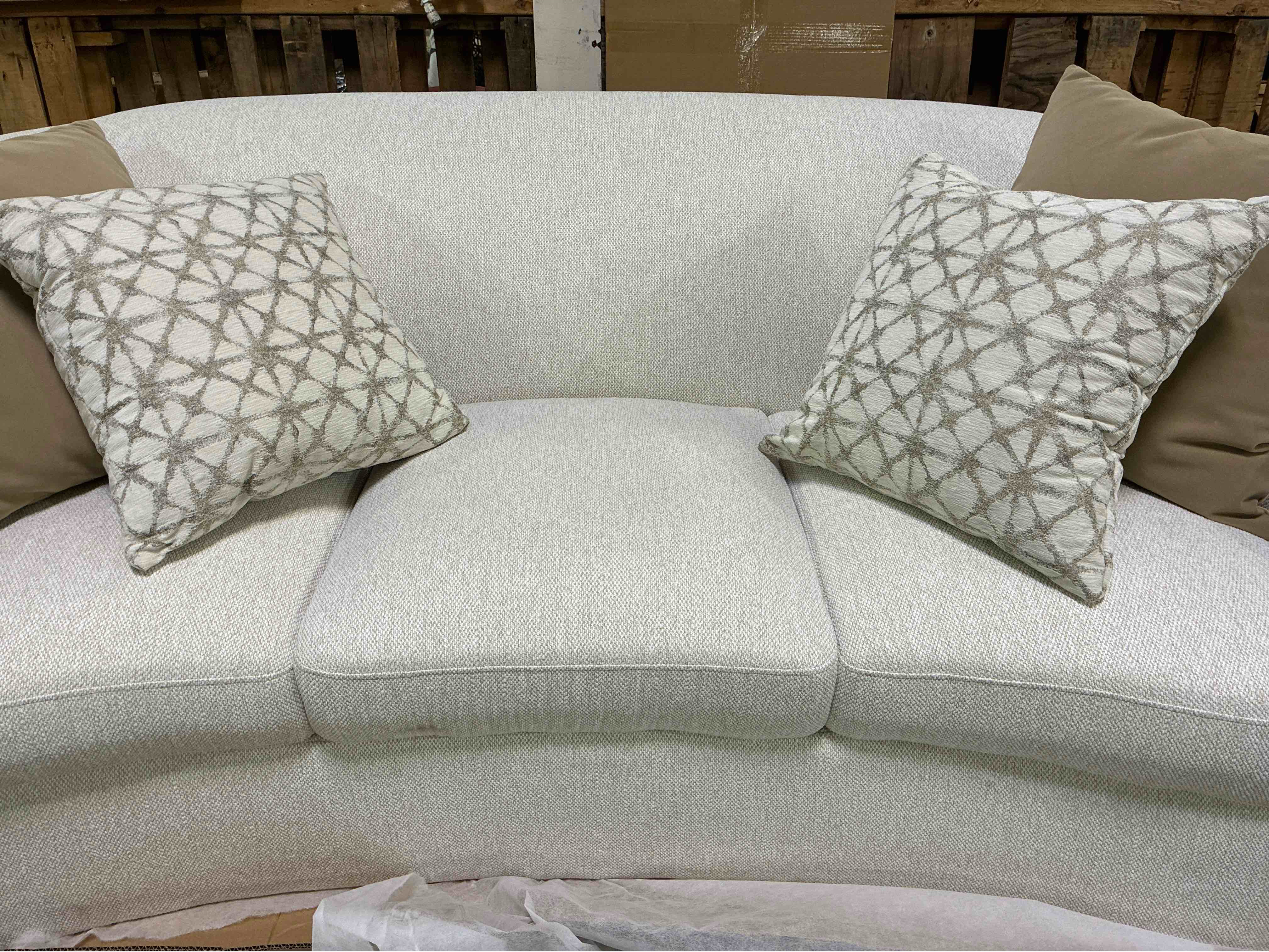Condition photo showing New/Like New for coaster home furnishings rainn latte white 3 seat upholstered curved sofa, accent pillows included. 88.5"w x 40"d x 33"h - 116.6lbs.
