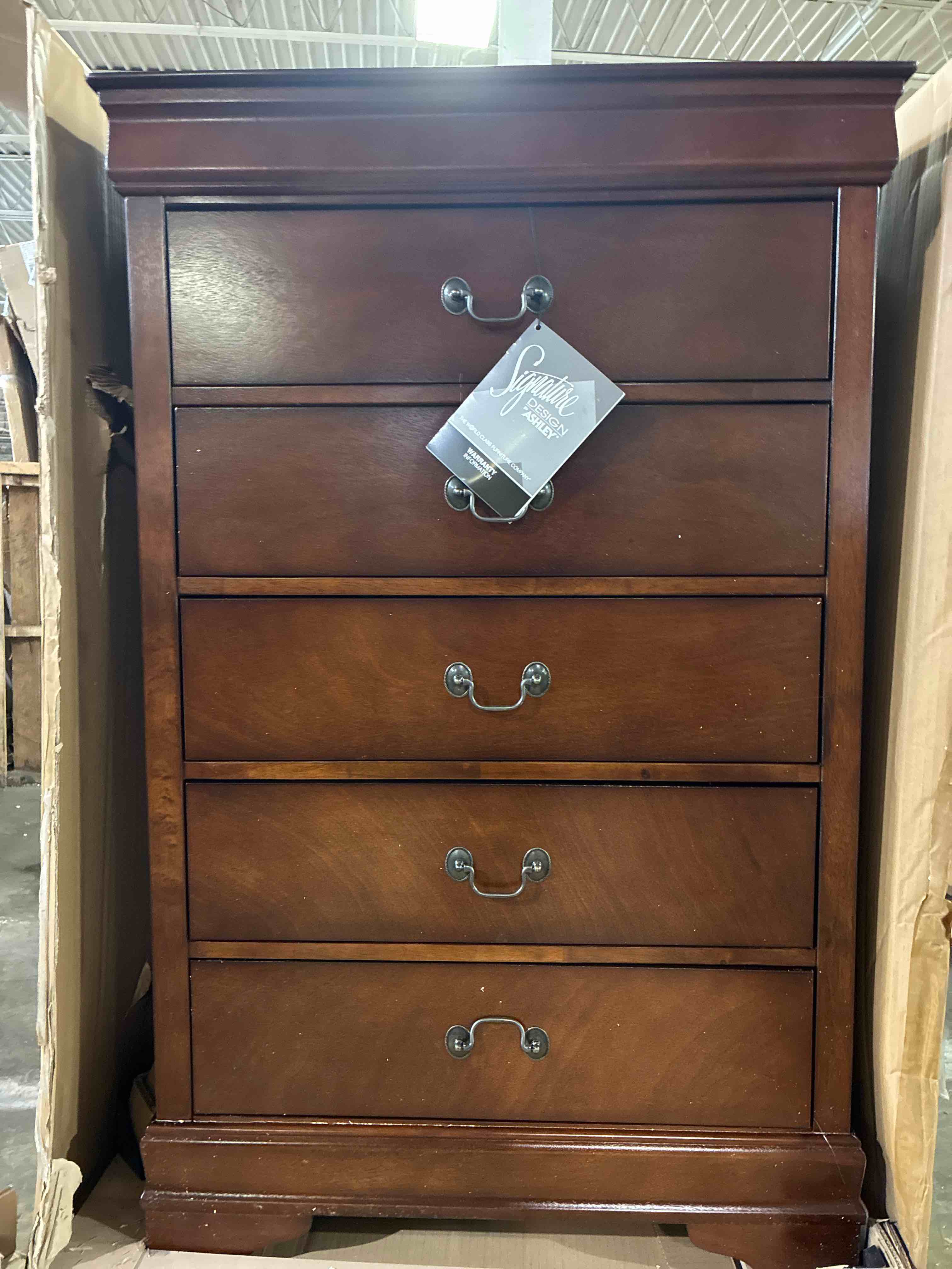 Condition photo showing Good Condition for signature design by ashley alisdair 5-drawer chest in warm dark brown with antique bronze handles. back left trim needs resealed, small scratch on middle drawers, otherwise brand new.