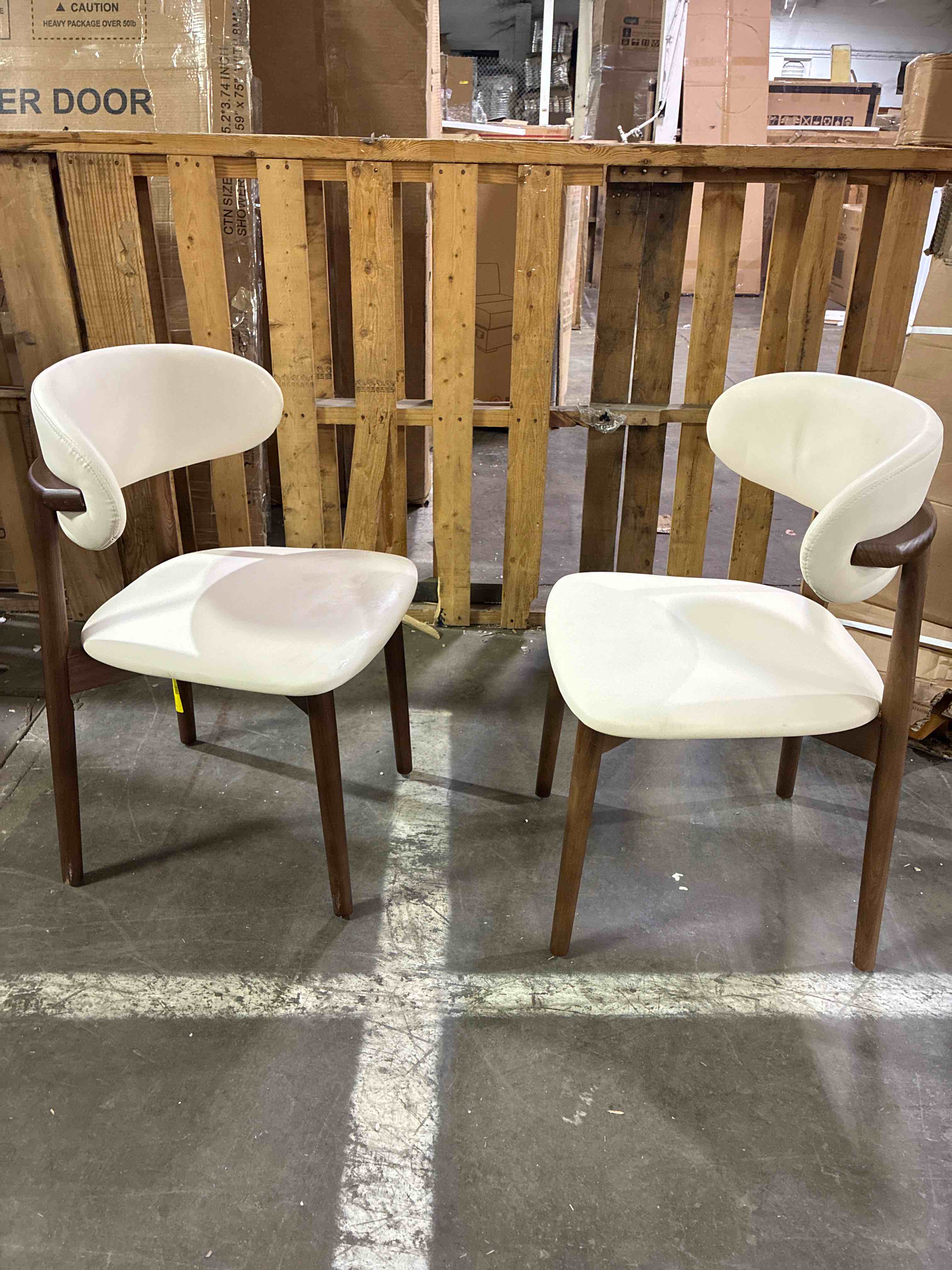 Condition photo showing New/Like New for white leather cushioned armless side chairs with wood legs in dark walnut finish. 