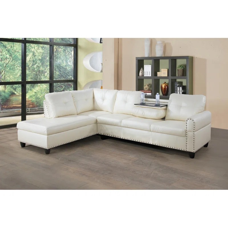 Louvenia 2 - Piece Off White Vegan Leather Silver Button Tufted L Shaped Sectional with Chaise and 2 Cup Pull Down Center Console. 2 Boxes complete item, hairline tear along upper left backing otherwise brand new, accent pillows included.
