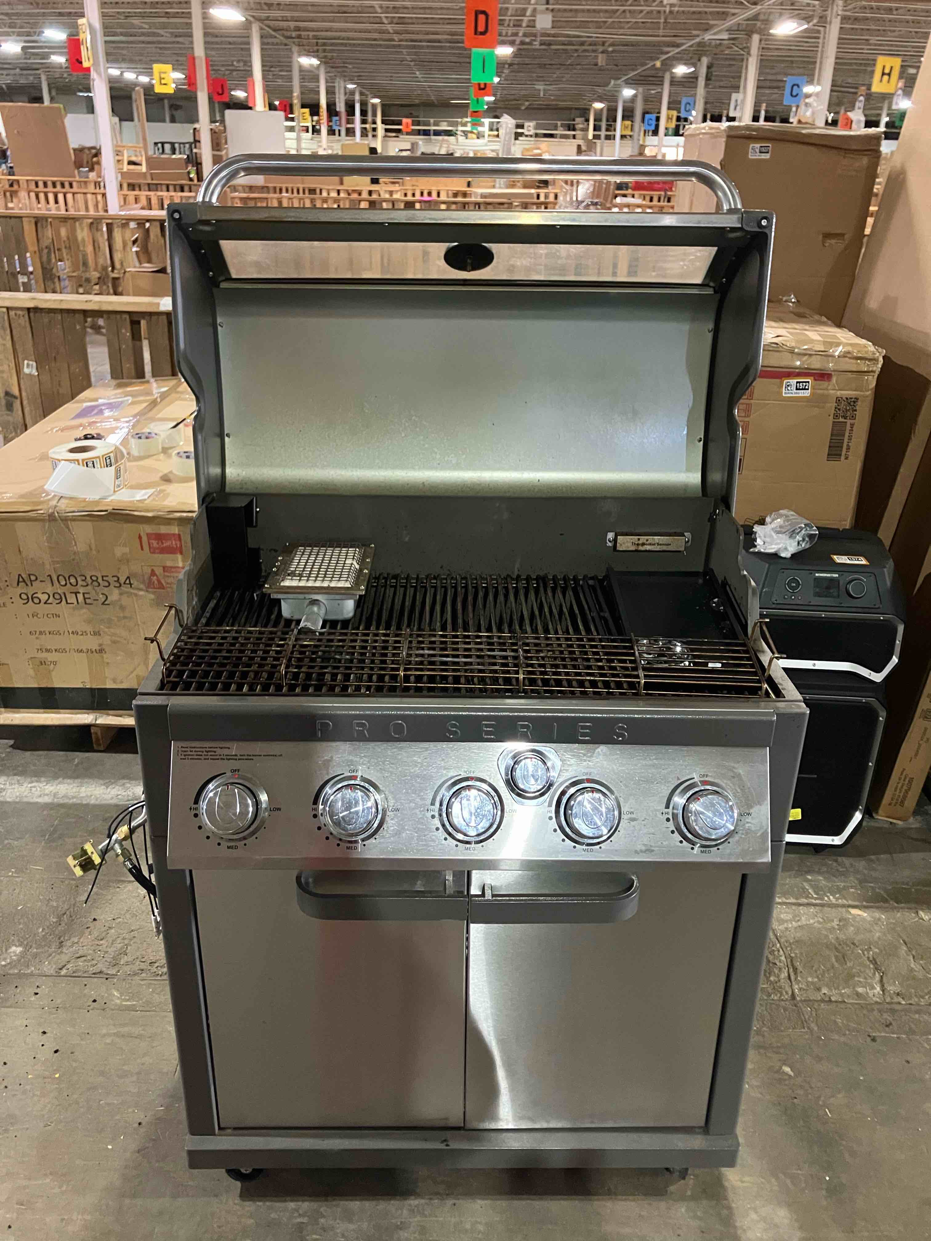 Condition photo showing As Is for Member’s Mark Pro Series 5-Burner Gas Grill with Thermostatic Control and Grill Cover - (Side burners missing/need replaced, can be found at appliancefactoryparts.com)