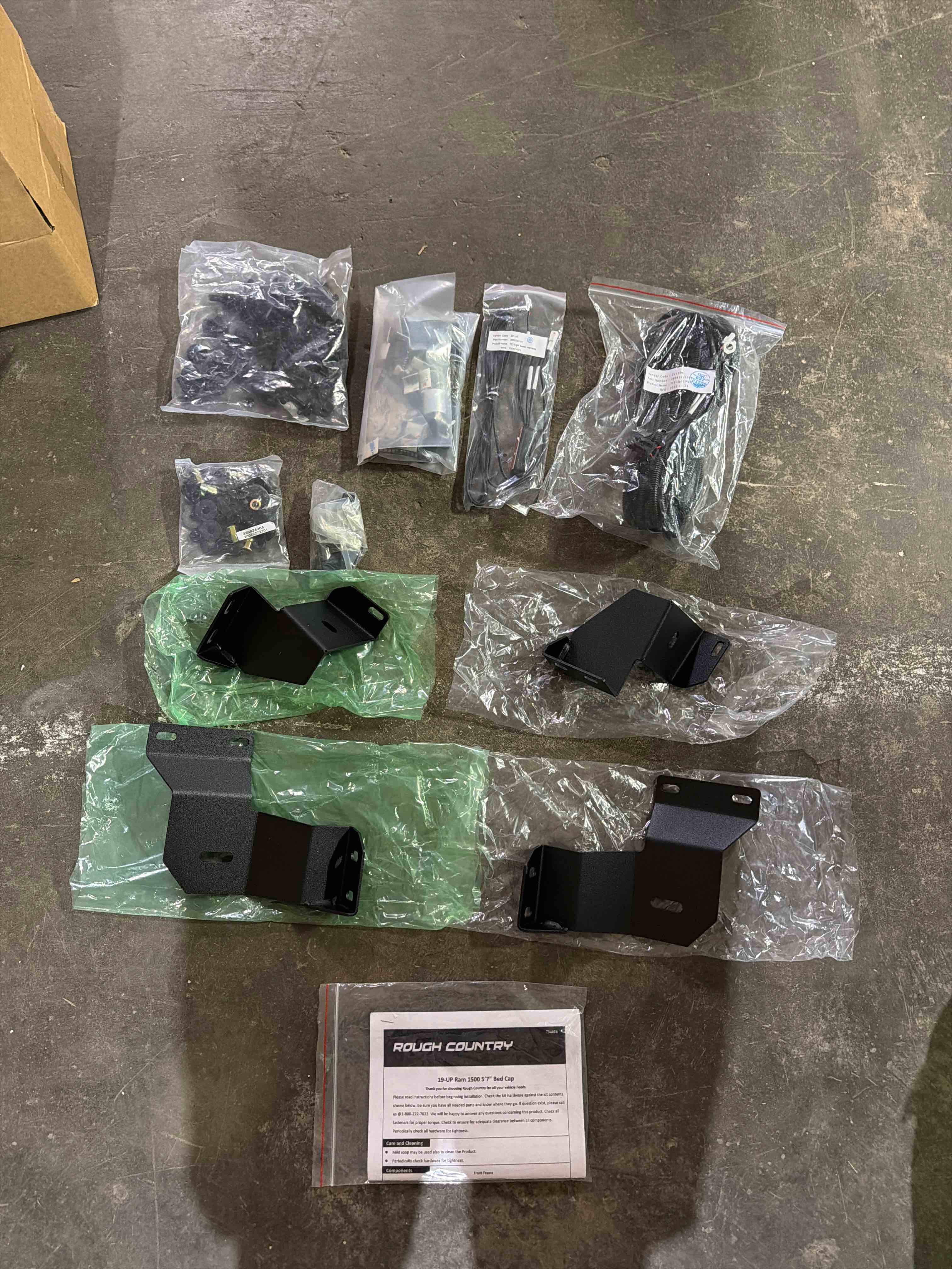 Condition photo showing New/Like New for truck bed cap, 6piece modular design, 5x7 bed, ram 1500 (19-26)/1500 trx (21-24), full opening gullwing doors,tough lockable panels and a third brake light, easy lift struts, bottom of back panel has a small bend(pictured), side lock panel is bent slightly(pictured), item is brand new otherwise(4 boxes total)