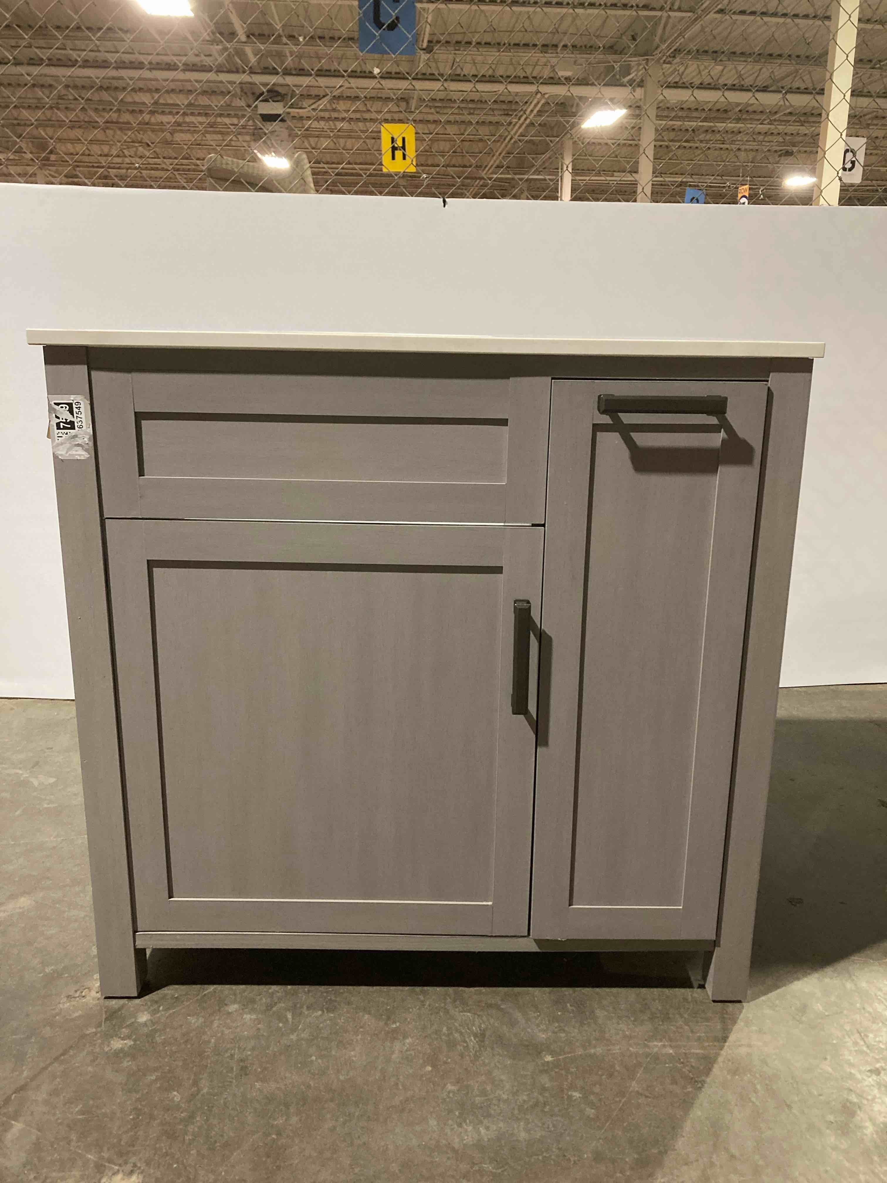 Custom Single Bathroom Vanity, Gunmetal Grey, Single Cabinet, Pull Out 2 Drawer Side Compartment, White Left of Center Solid Qaurtz Sink Top, Antique Iron Handles. Some scuffing on back of sink otherwise brand new 37” W x 20” D x 36.3” H