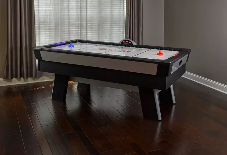 Atomic Top Shelf 7.5’ Air Hockey Table with 120V Motor for Maximum Air Flow, High-Speed PVC Playing Surface for Arcade-Style Play and Multicolor LED Lumen-X Technology to Illuminate Play. Right corner and edge has some chipping, minor scratch on leg. 