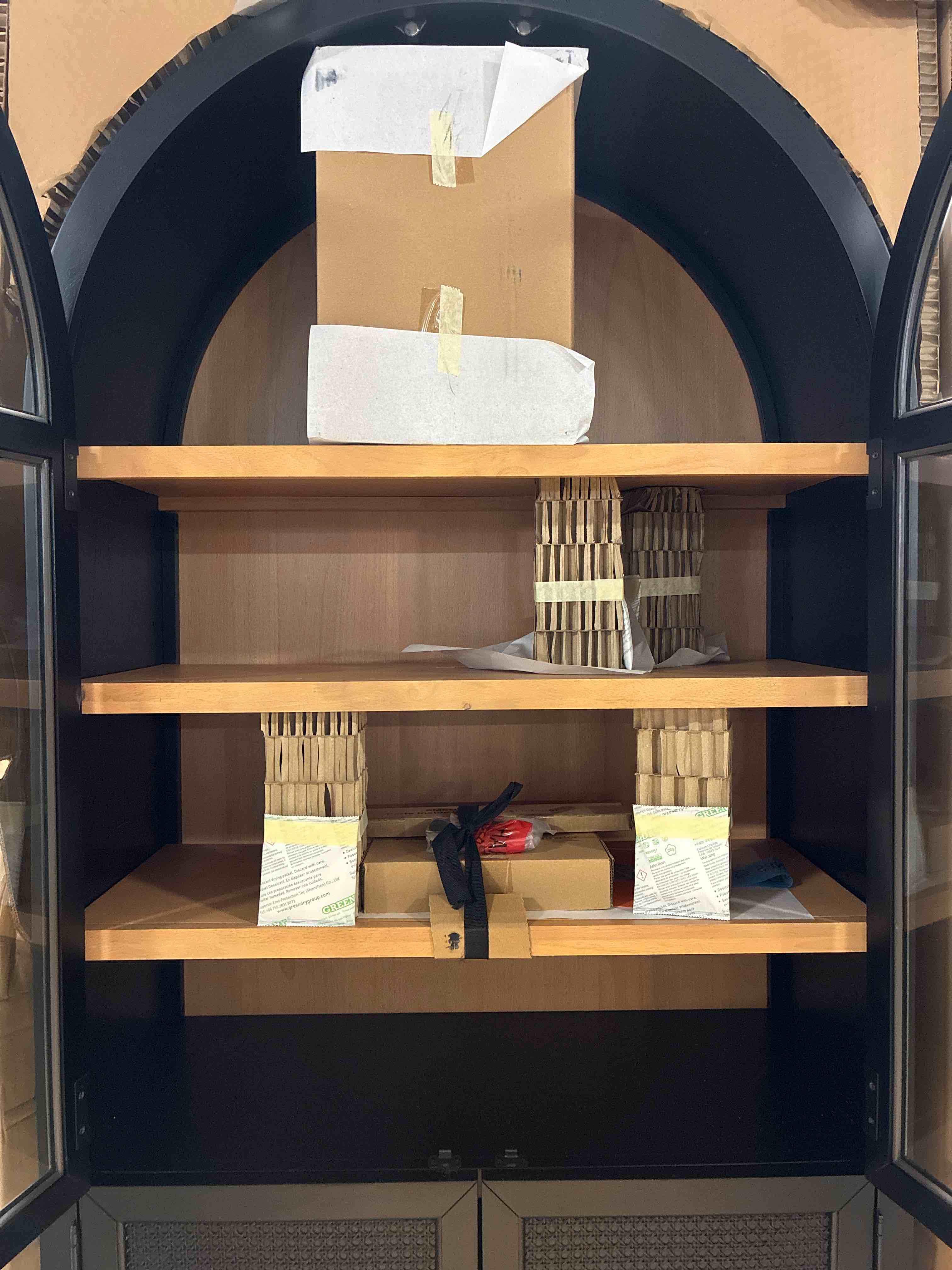 Condition photo showing New/Like New for Member's Mark Enzo Storage Cabinet With Rattan Cabinet Doors in Black with Gold Brushed Metal Handles, Arched Glass Doors, Open Space Base Cabinet, and 4 Tier Shelves. 