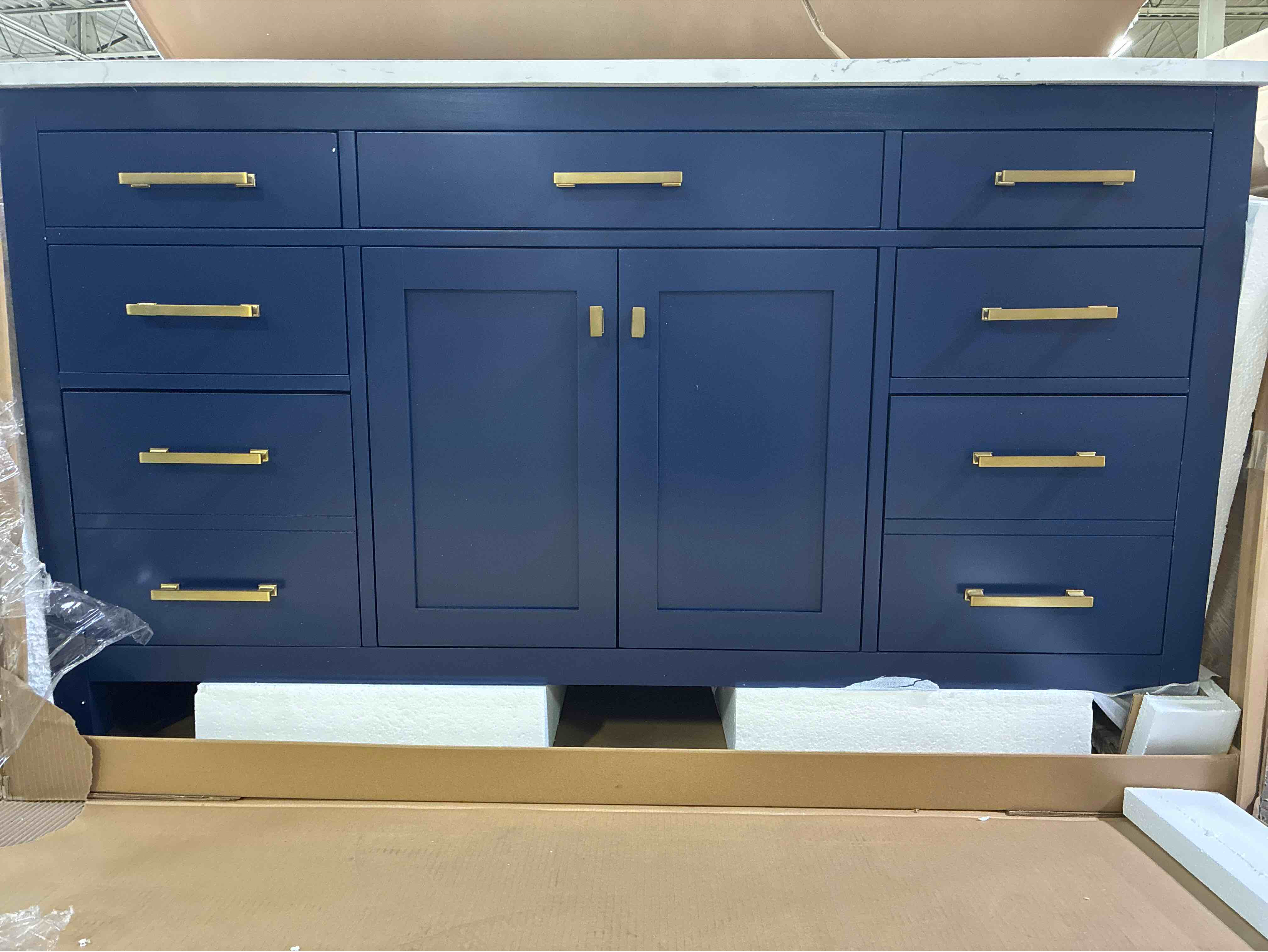 Condition photo showing Good Condition for Ajhane 60" Navy Blue Poplar Wood Single Bathroom Vanity 6 Drawer Dresser, Single Shelf Cabinet, Gold Brushed Metal Handles, Marble Painted Carrara Stone Sink Top. Hairline crack along front, Minor chip along back, otherwise beautiful condition. 34'' H X 60'' W X 22'' D