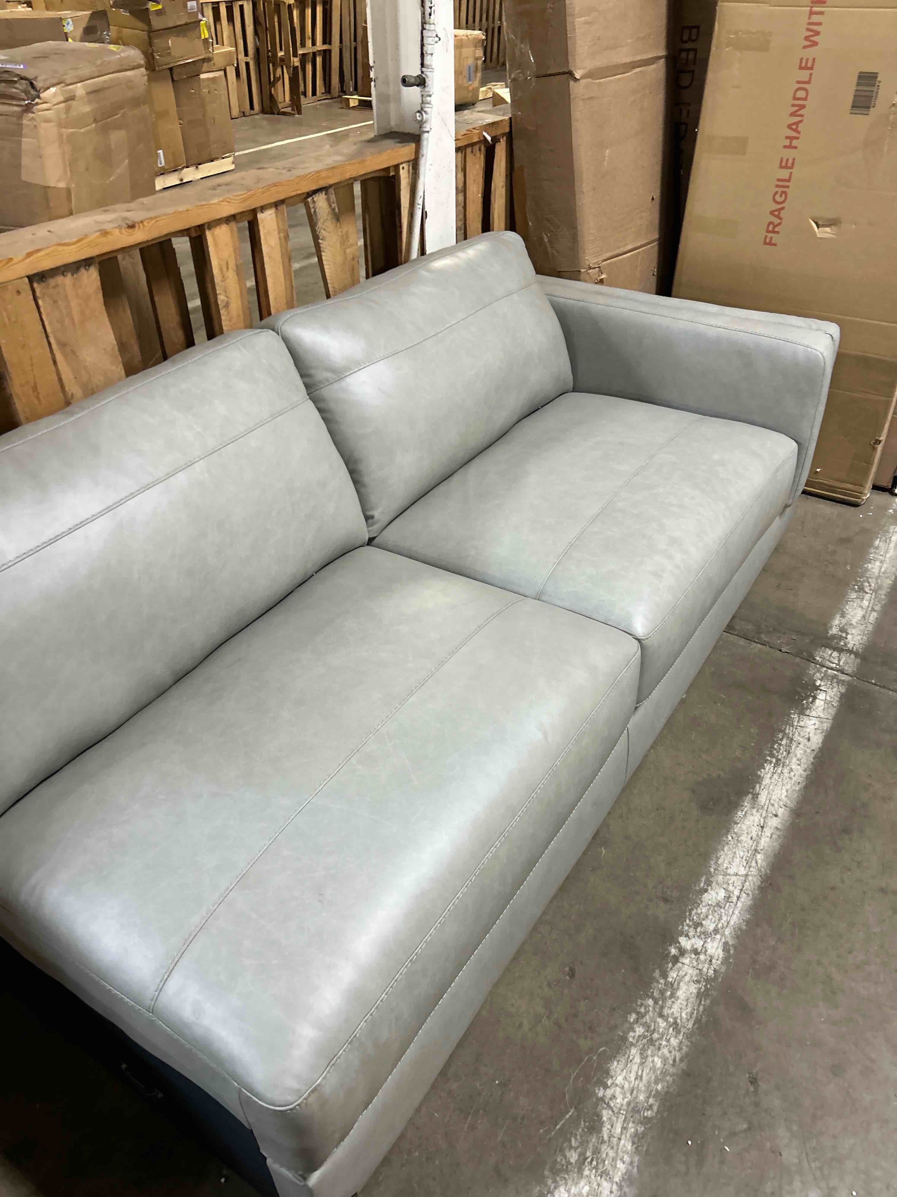Condition photo showing As Is for Signature Design by Ashley Amiata Modern L-Shaped Left-Arm Facing Leather Match 2-Piece Sectional with Chaise, Light Gray(left hand side only)