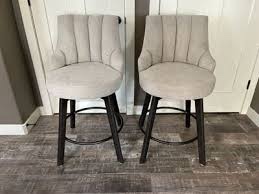 set up to upholstered went back, rotating barstools with gray wooden legs