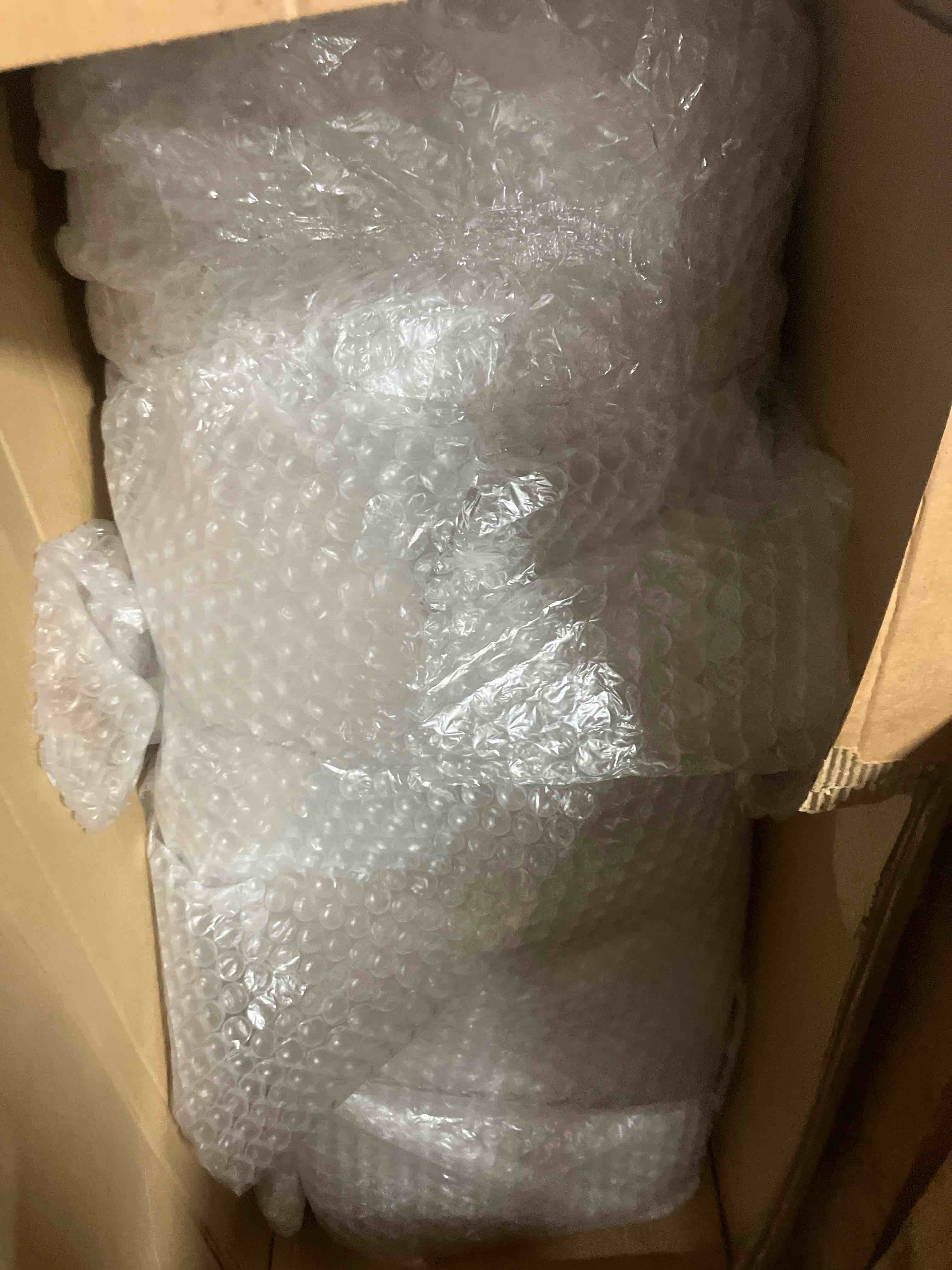 Condition photo showing Good Condition for 5X 1.5 foot glass table with eccentric modern metal base. (toolbox is glass table top in bowl wrap, short box is the base) (only good condition due to damage to box)