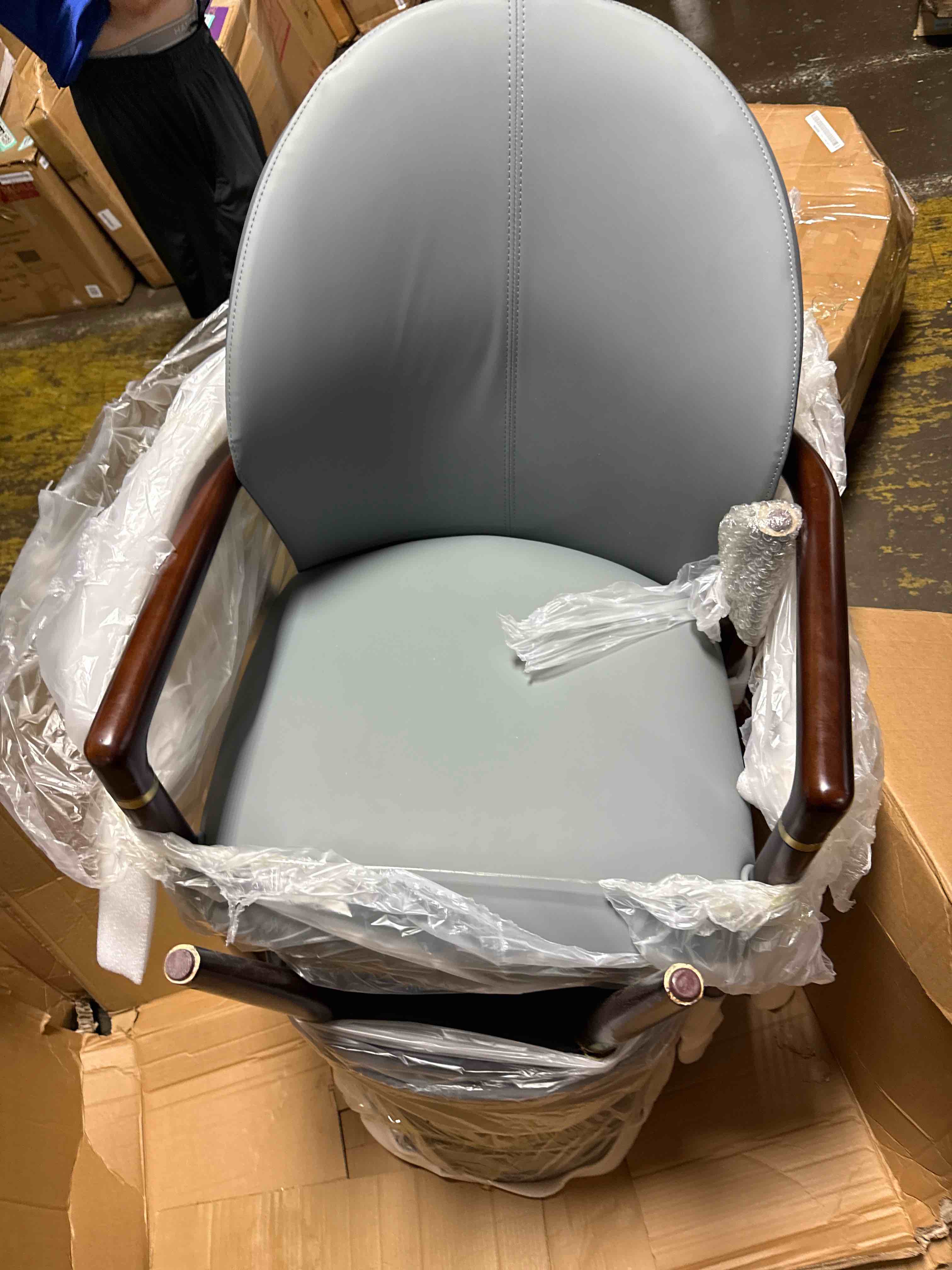 Condition photo showing As Is for leisuremod leather dining chair, ergonomic armchair with padded seat, rubberwood base & gold accents for modern kitchen, home & office in grey (arm of chair broken) 