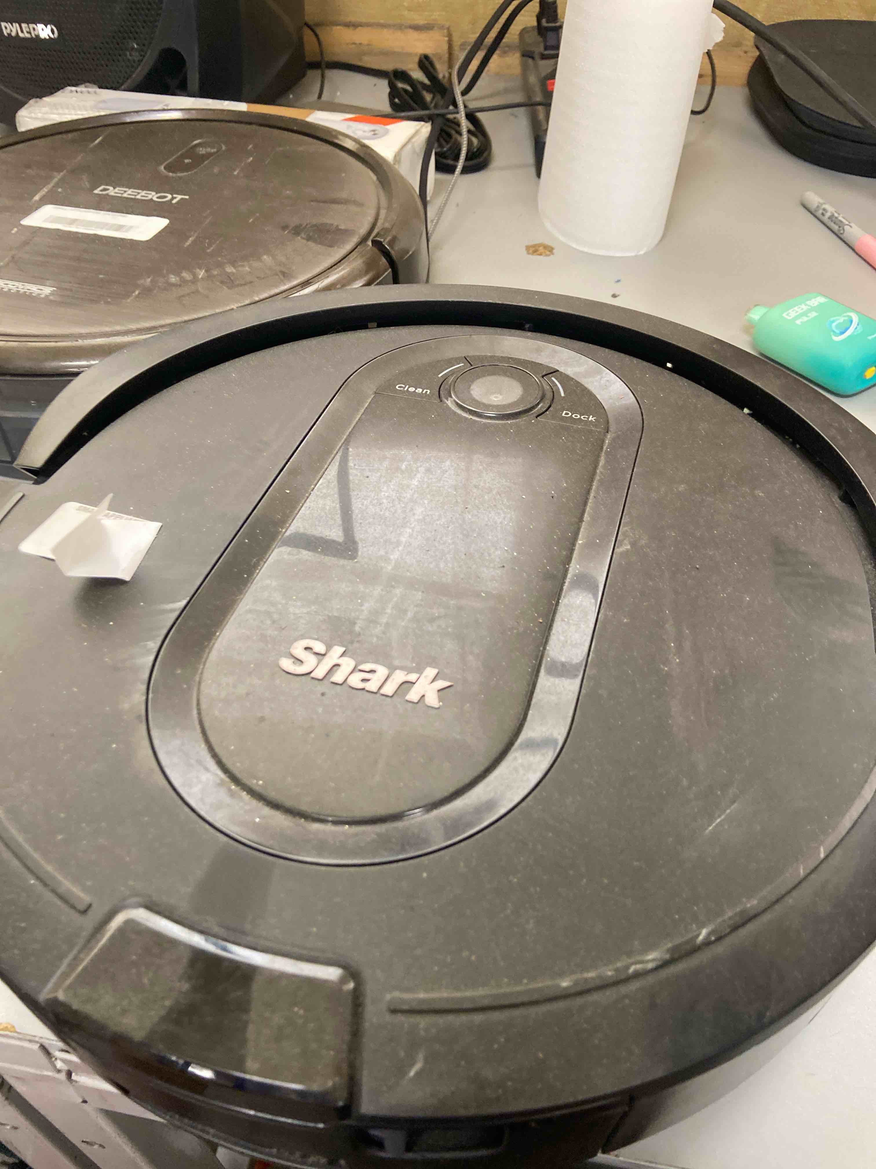Condition photo showing As Is for shark iq app-controlled self-emptying robot vacuum, rv100ae/ur1000sr - black (renewed)
