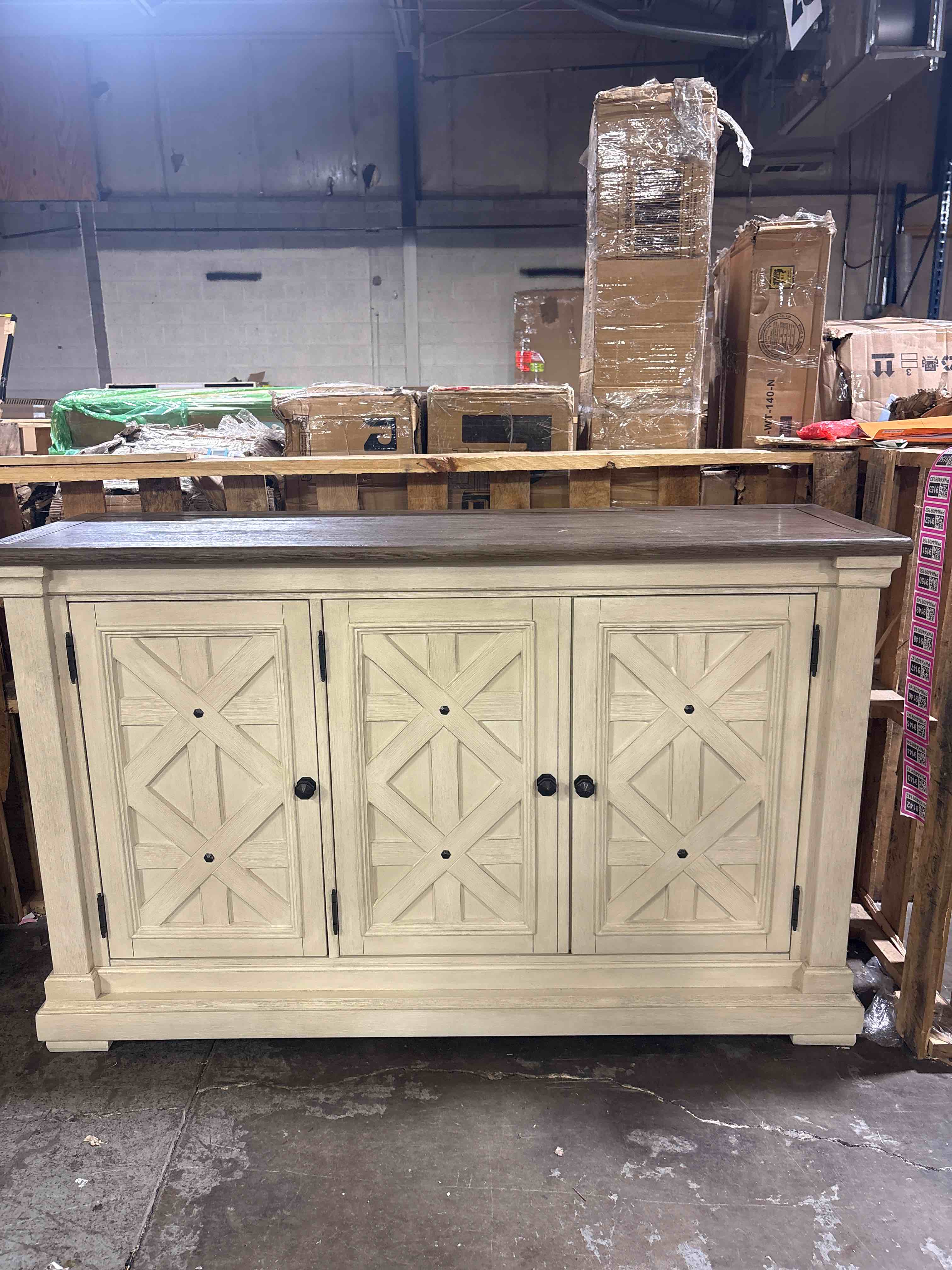 Condition photo showing New/Like New for signature design by ashley bolanburg french country dining room server, 3 doors, 2 adjustable shelves, wood, 57.88" w x 18.13" d x 36" h, 2-tone white & brown. minor shelf damage.