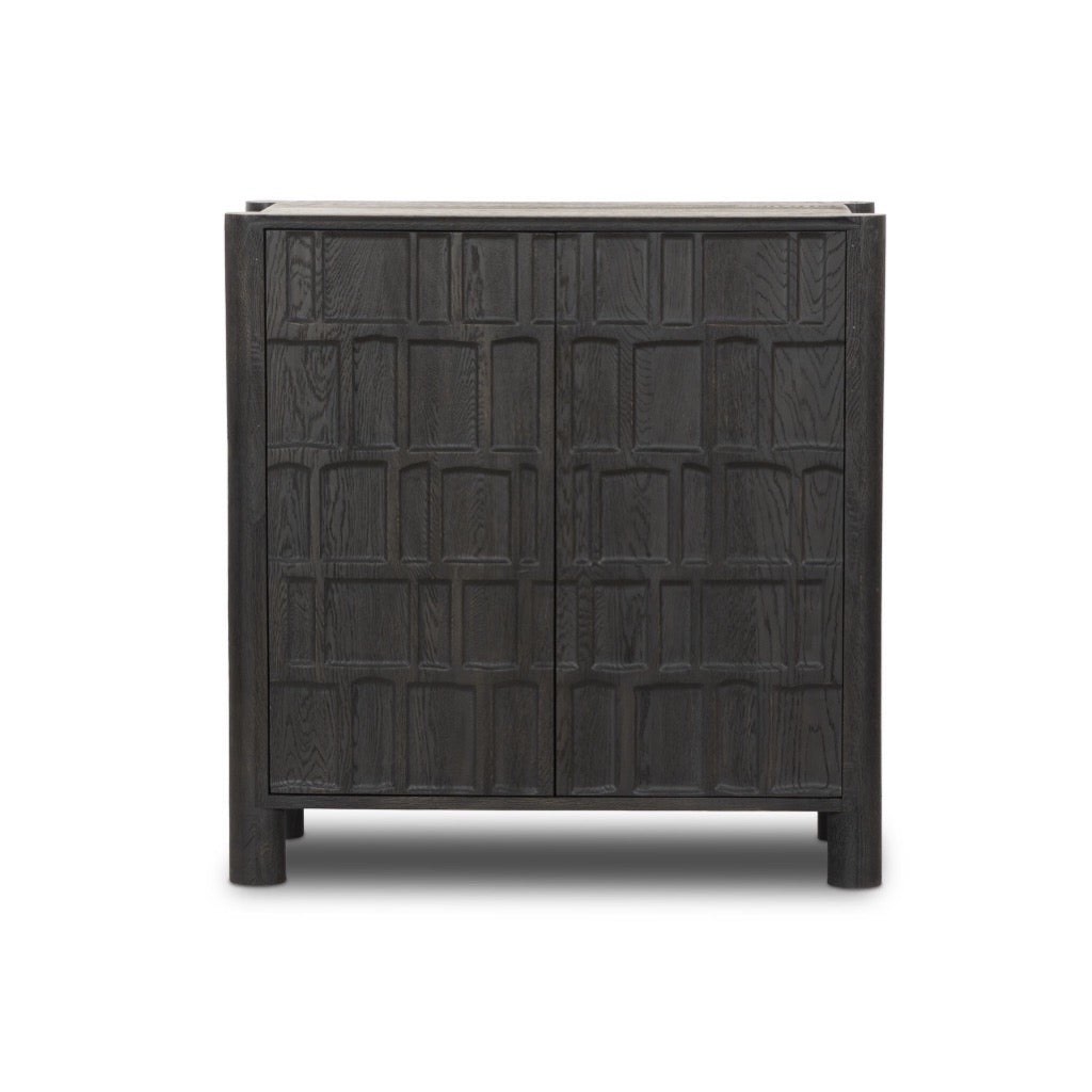 Ezri Black Oak Bar Cabinet with Geometric Carved Doors, Top to Bottom Rounded Legs, and 3 Storage Compartments. Chip along inner right door, small marks along right side otherwise beautiful condition. 42.00"w x 20.00"d x 43.00"h 