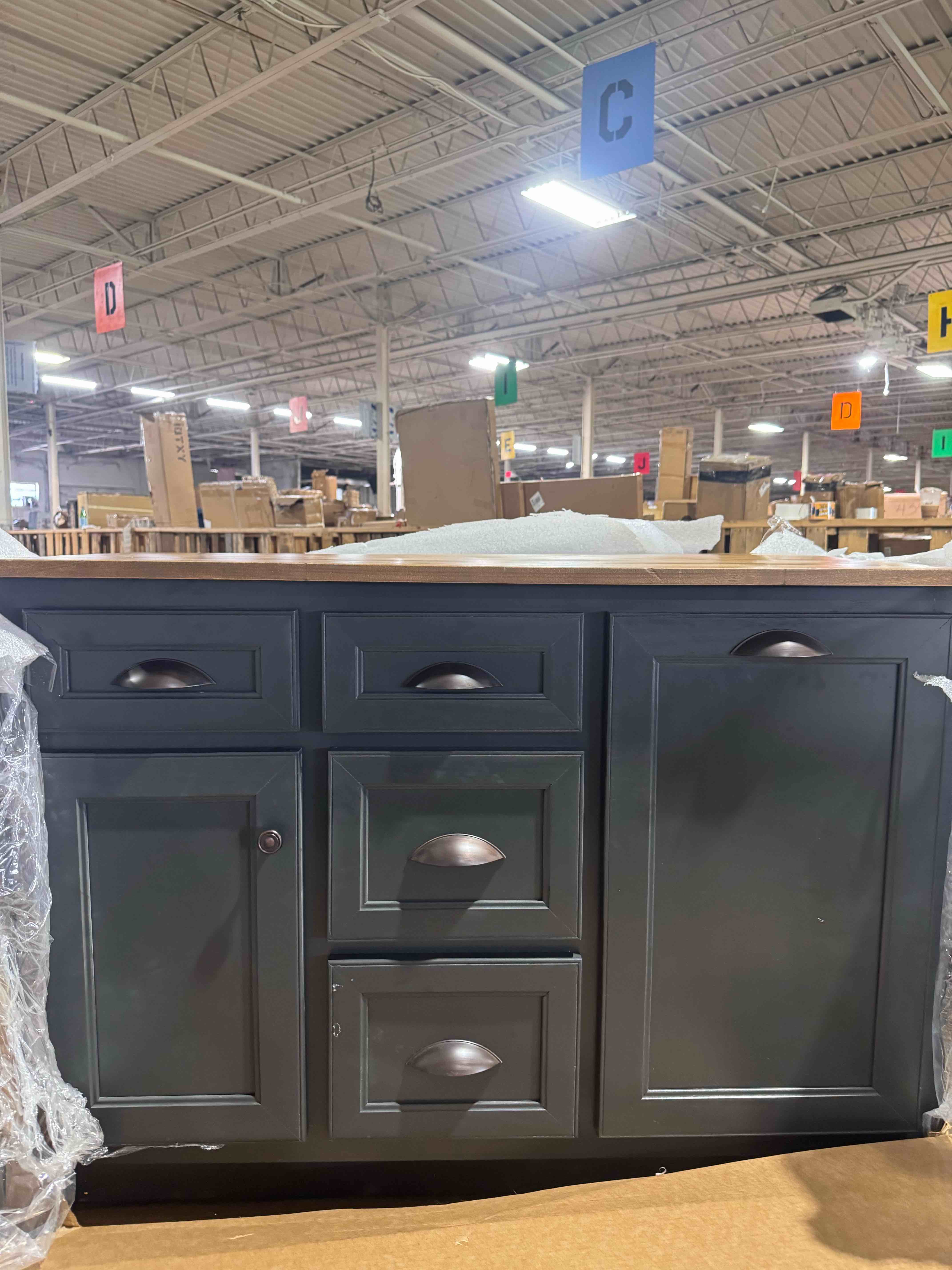Condition photo showing New/Like New for kitchen island with trash bin compartment, color: cherry wood and iron ore 25.00 x 50.00 x 36.00 inches