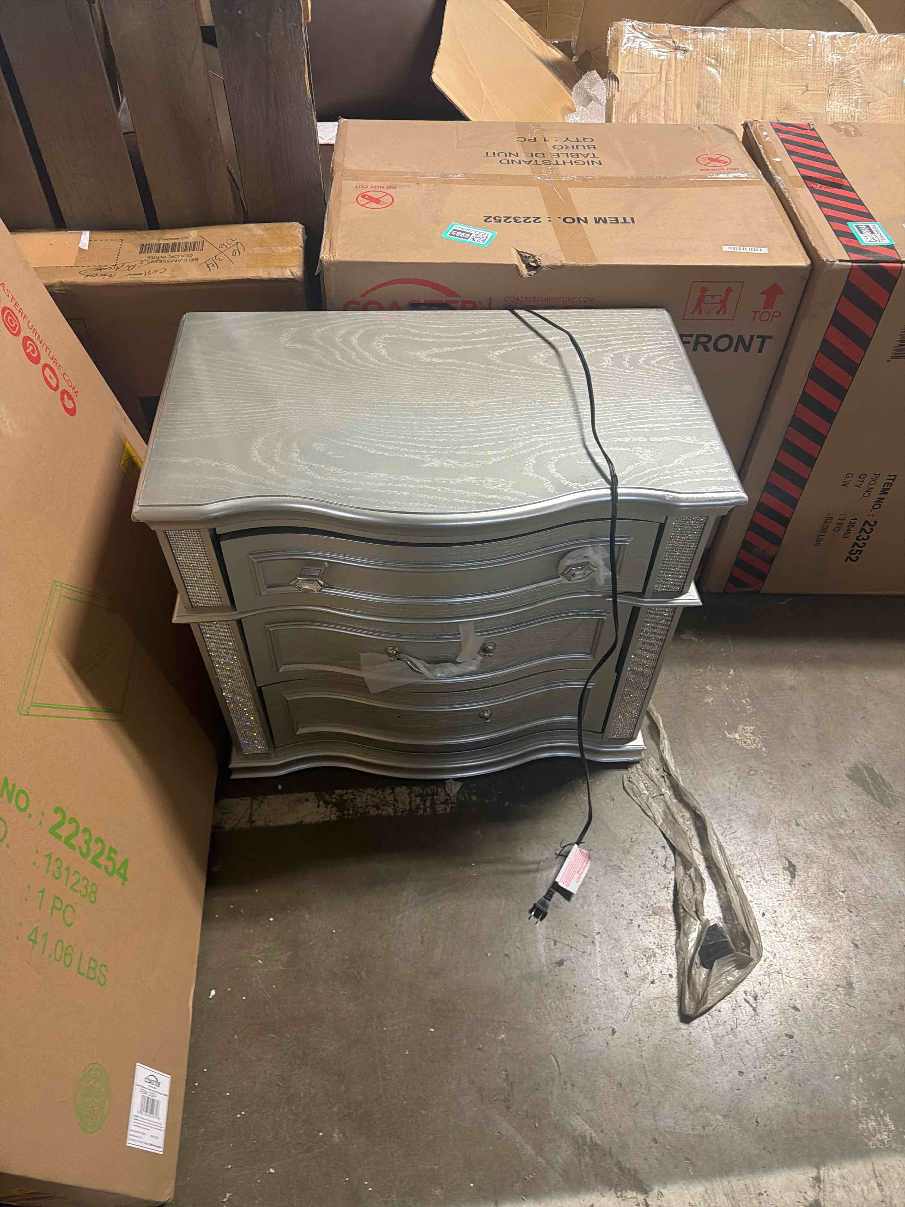 Condition photo showing As Is for pemberly row 3-drawer wood nightstand, silver oak finish, 31.5" h x 29.75" w x 18" d, felt-lined top drawer, glittering accent panels, usb charging ports, modern glam bedroom storage