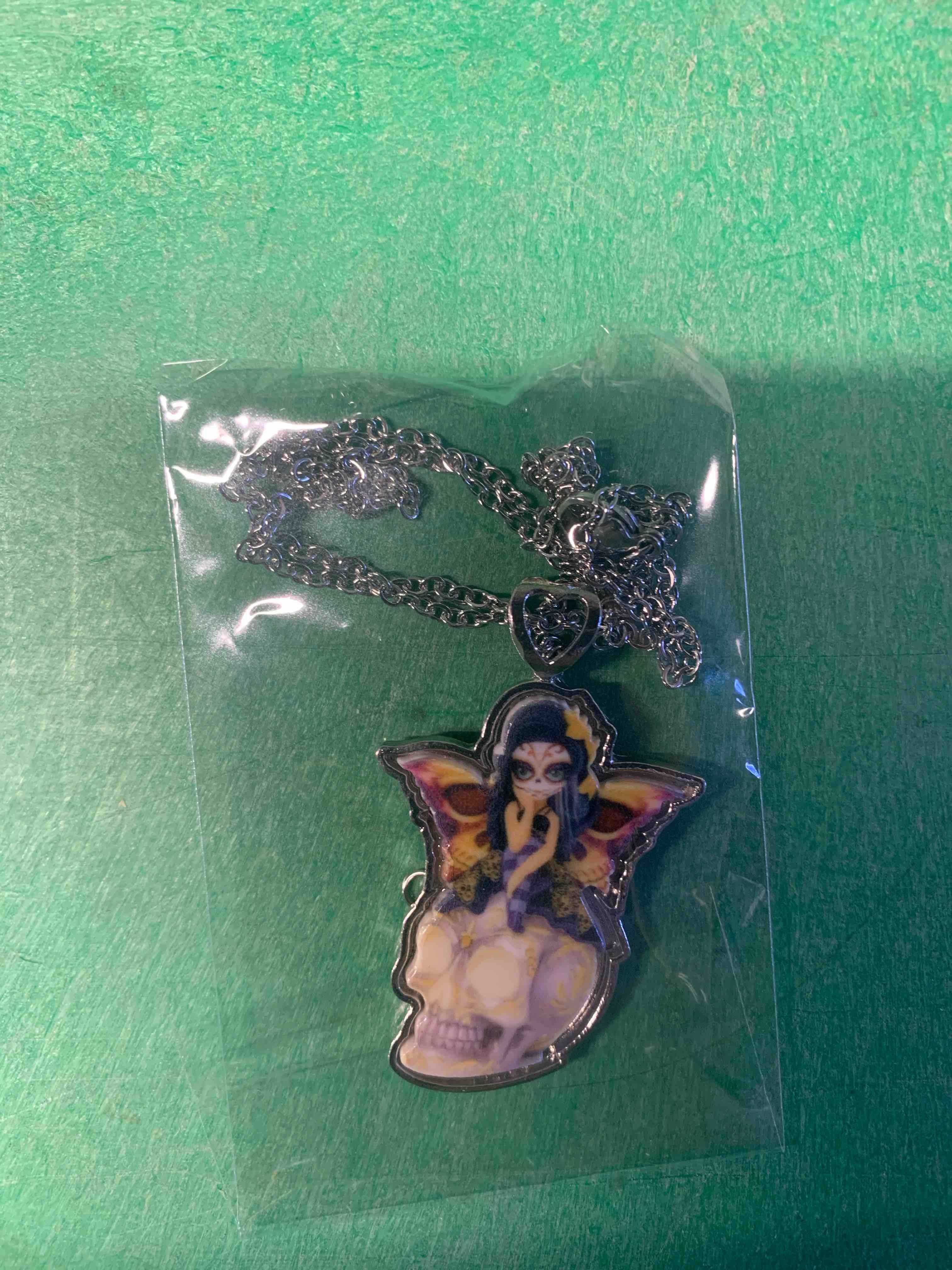 necklace fairy sitting on a skull