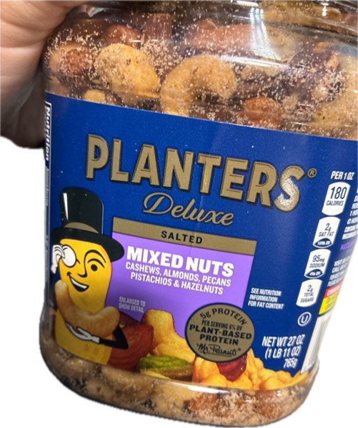 Condition photo showing As Is for PLANTERS Deluxe Mixed Nuts with Sea Salt, 27 oz Resealable Container - Variety Mixed Nuts Snacks with Cashews, Almonds, Pecans, Pistachios, & Hazelnuts - Energy Boost - Kosher (BB 10/25/25)