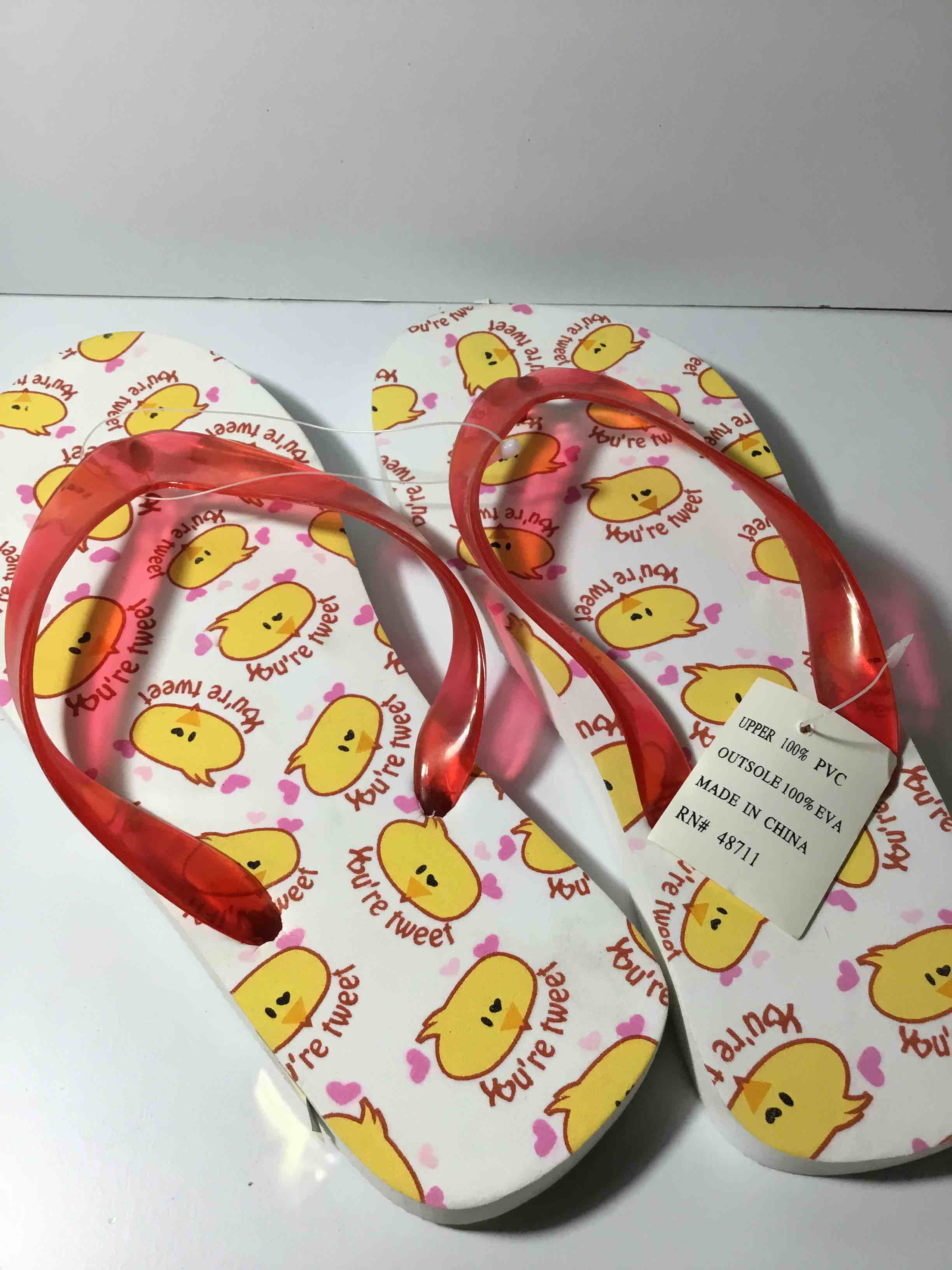 Size M This is a pair of flip-flops with a yellow chick print and red translucent straps