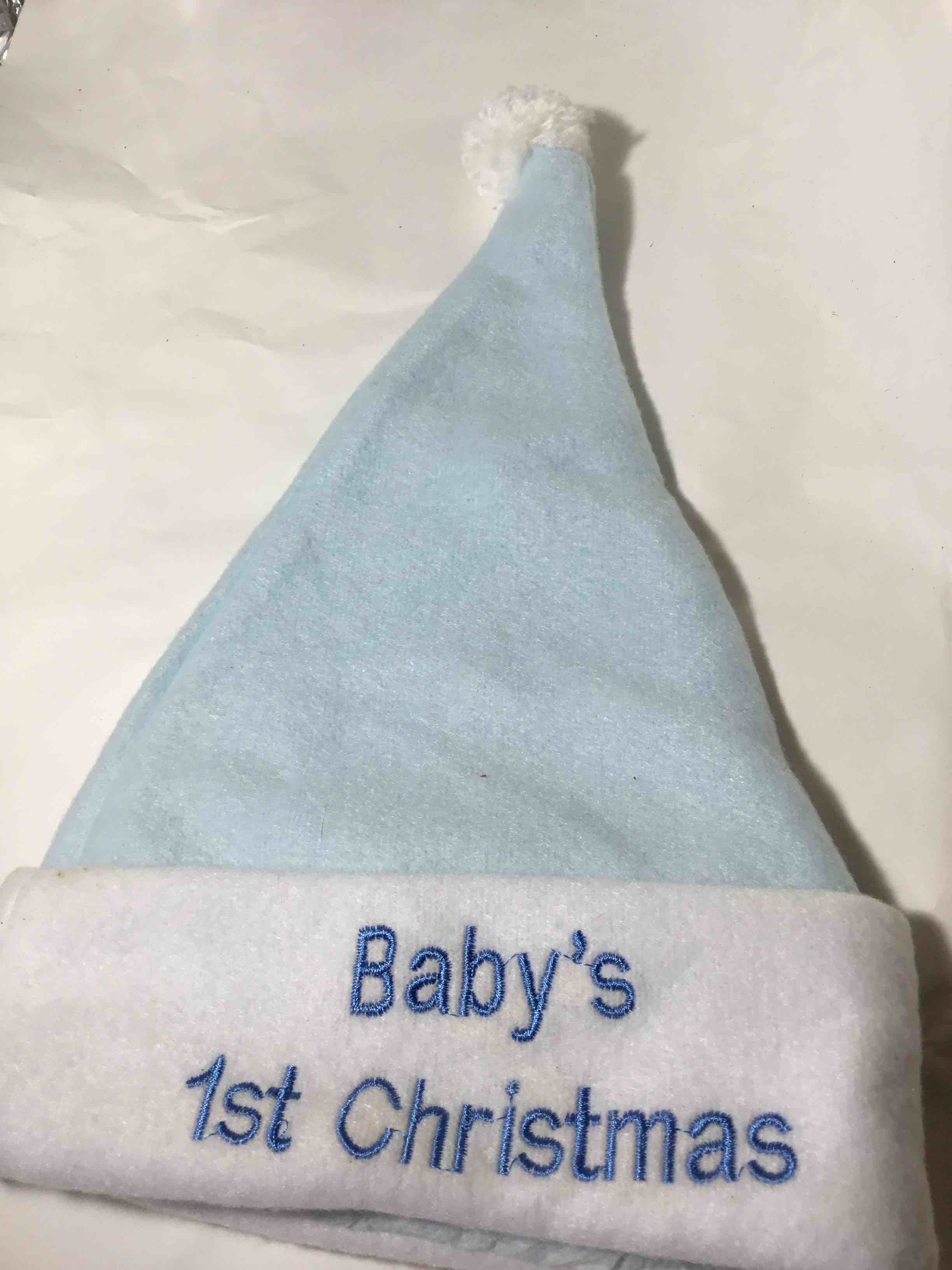 Light blue Santa hat with "Baby's 1st Christmas" embroidered on the white trim. 