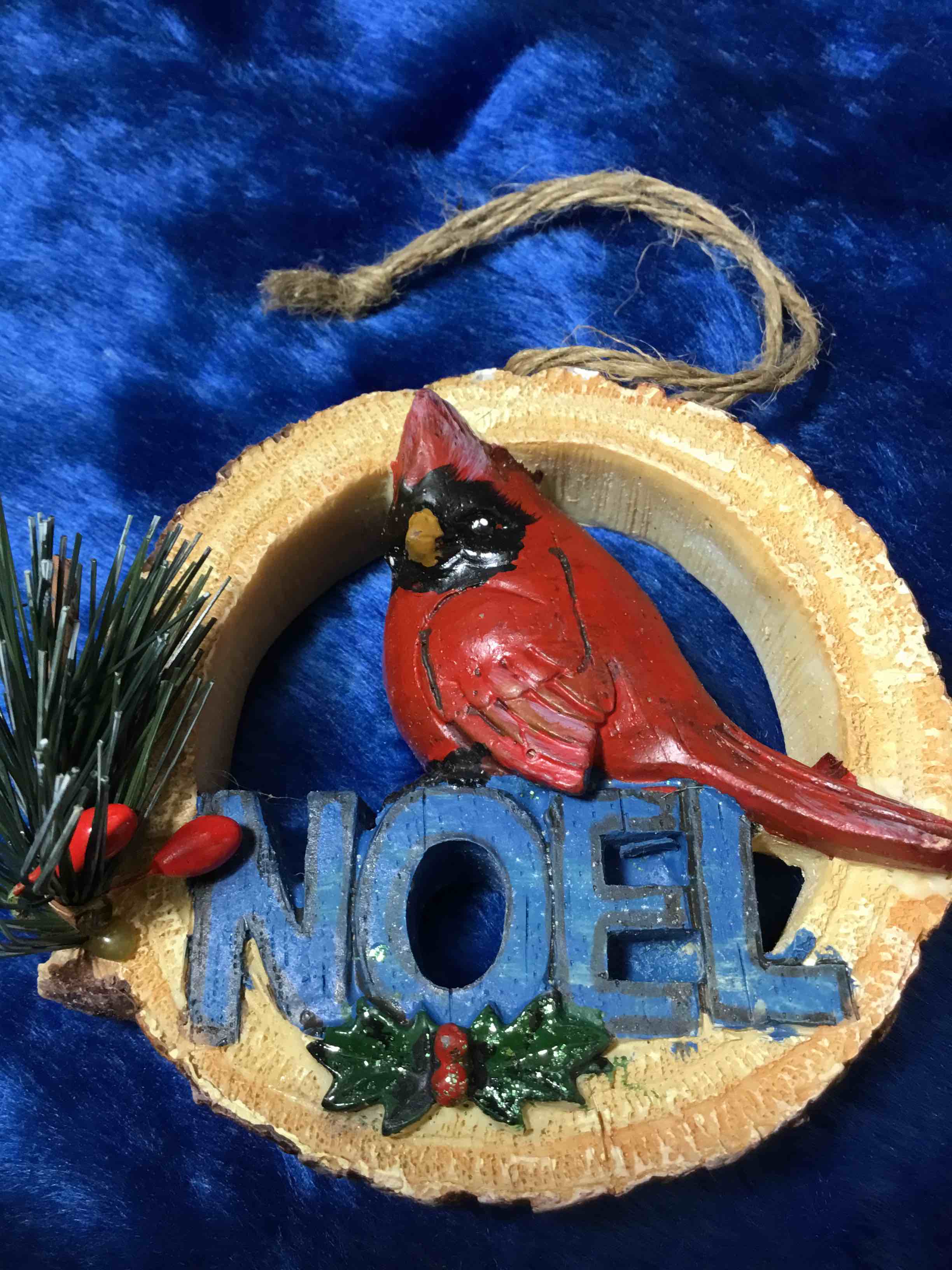 Christmas ornament featuring a hand-painted red cardinal perched on the word "NOEL