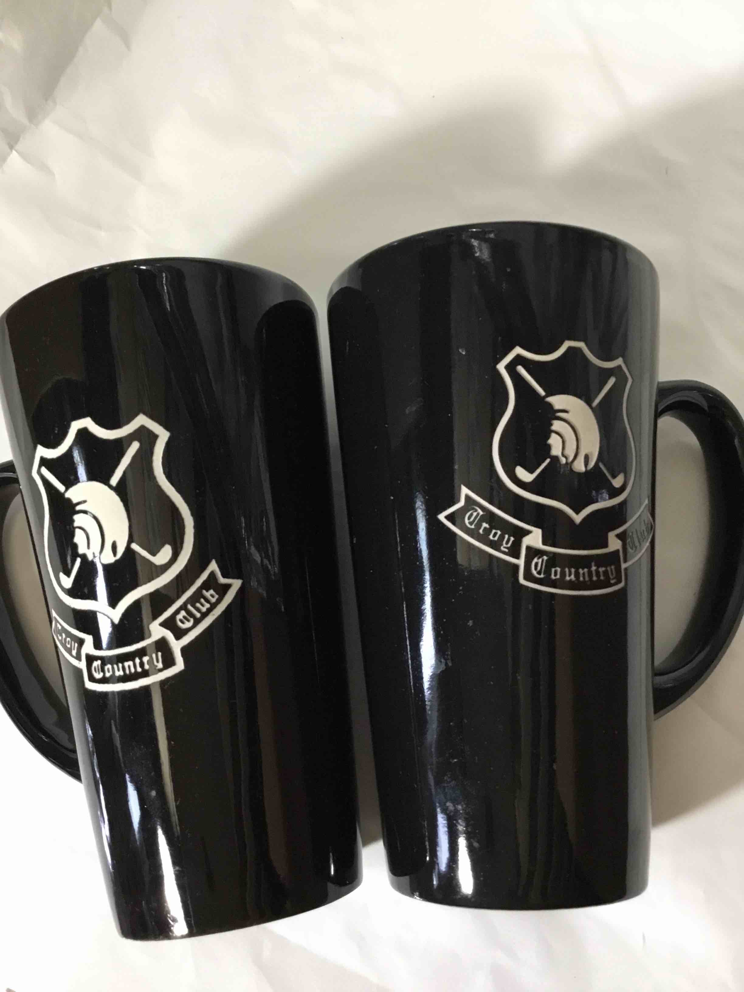 Tall black ceramic coffee mug set featuring a logo for the "Troy Country Club".