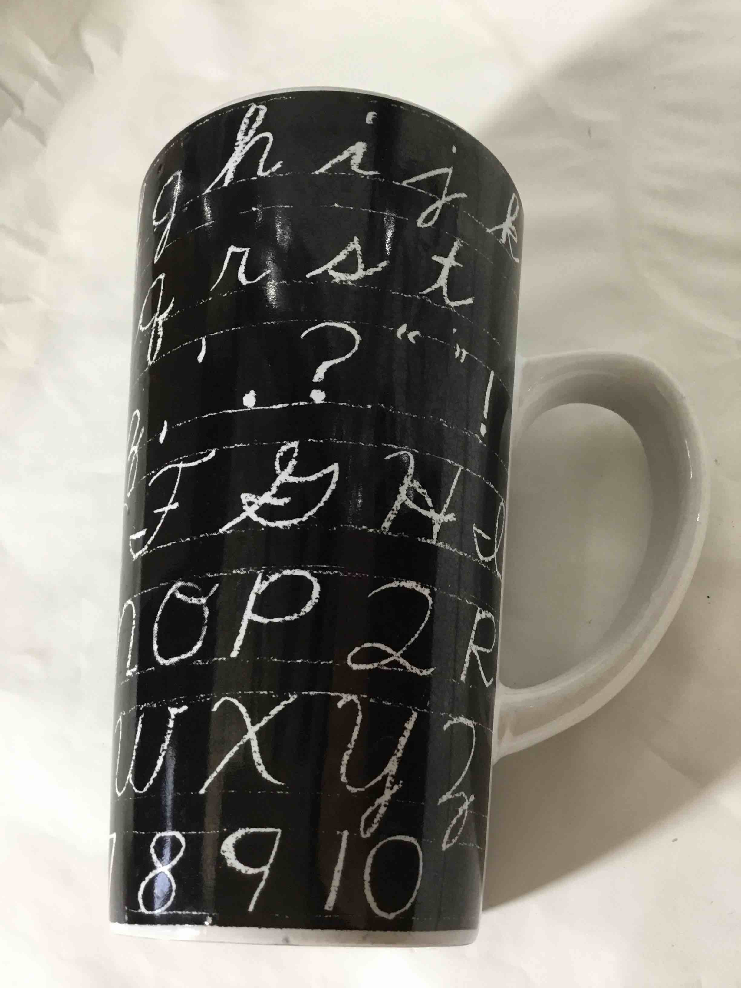 Tall mug with a chalkboard-style cursive alphabet design