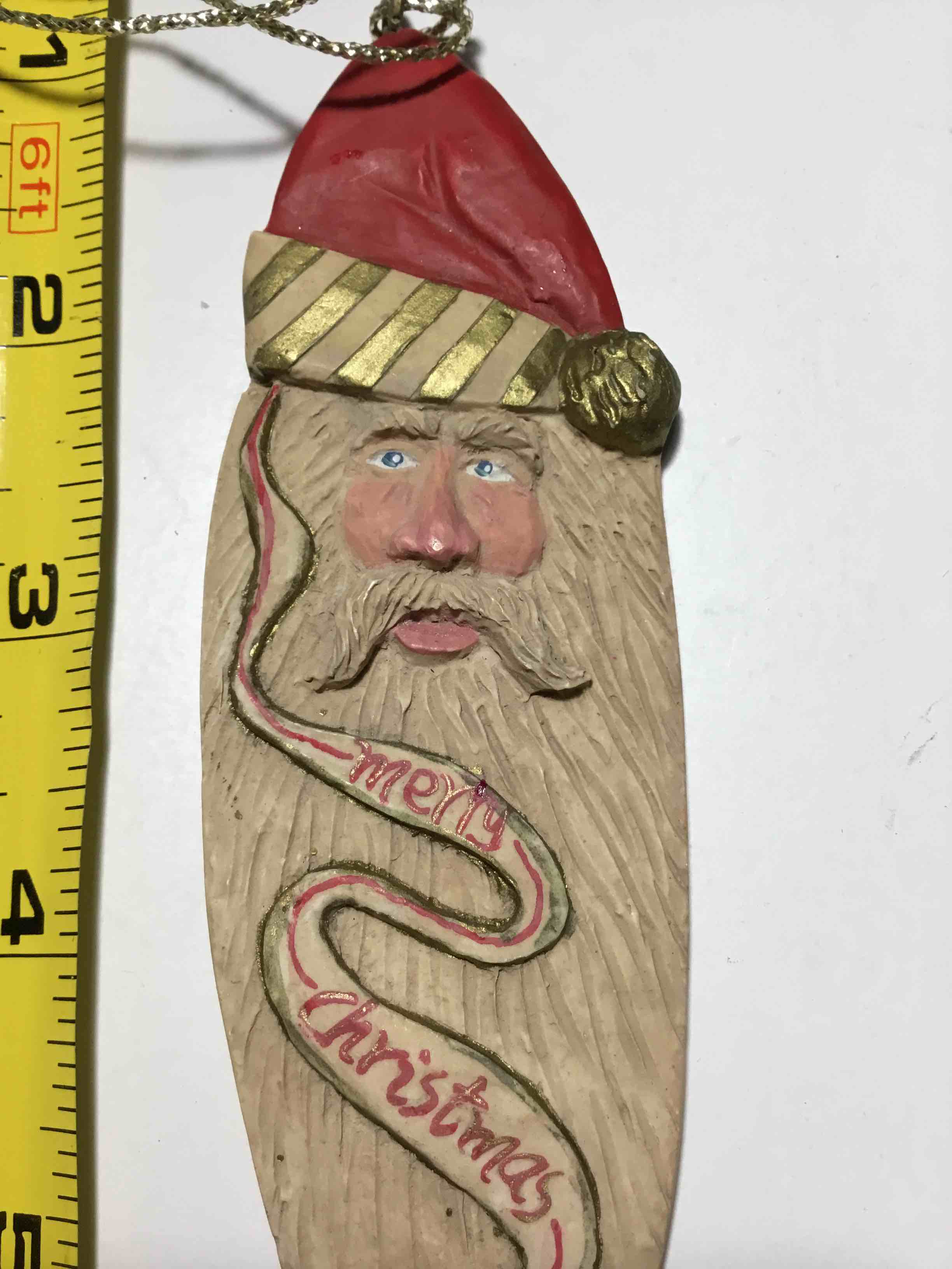 Carved wooden icicle ornament featuring an old-world Santa Claus
