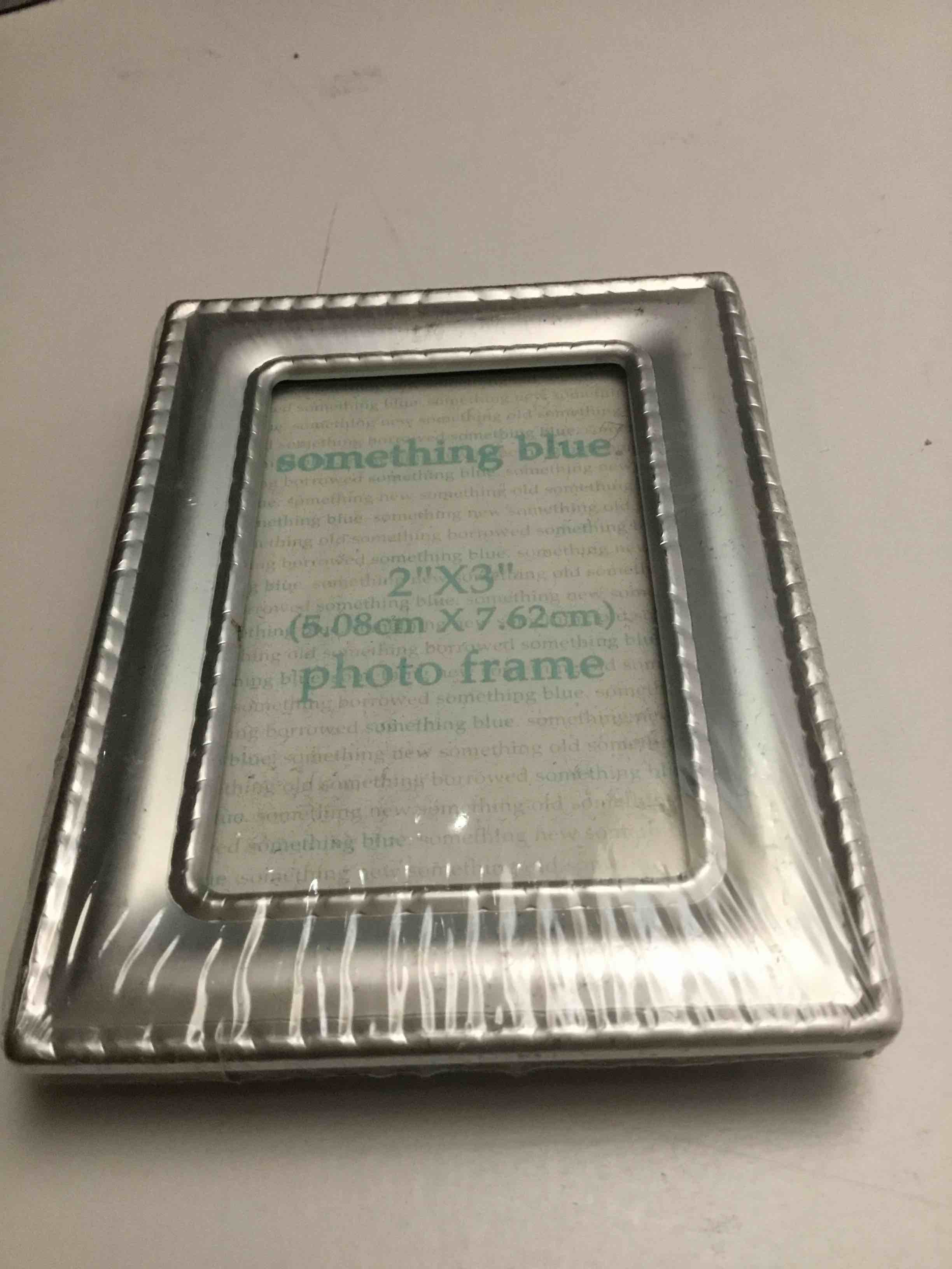 Silver-toned, rectangular frame with a beaded border design 2”x3”