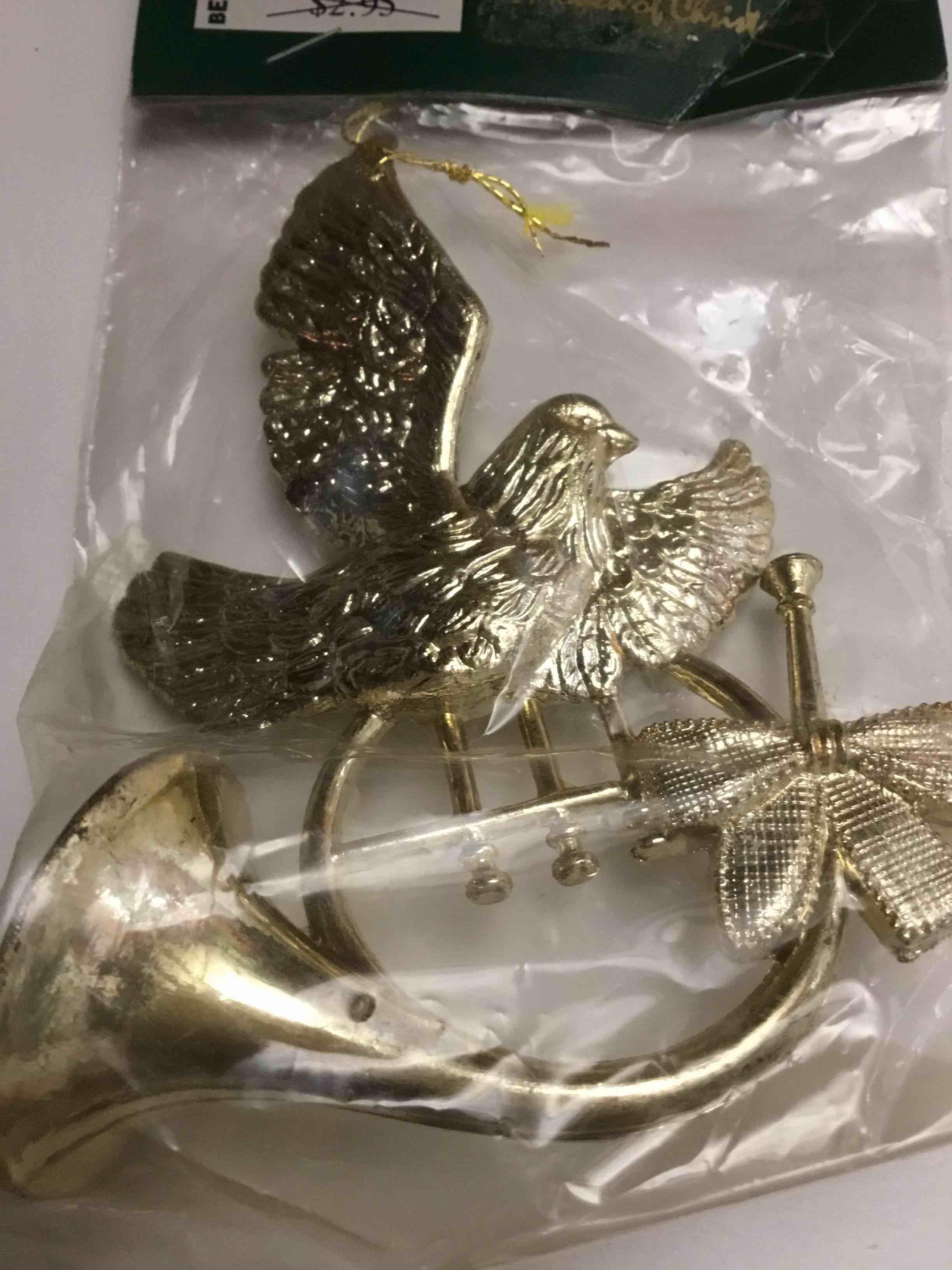 Gold plastic Christmas ornament featuring a dove bird with a bugle horn